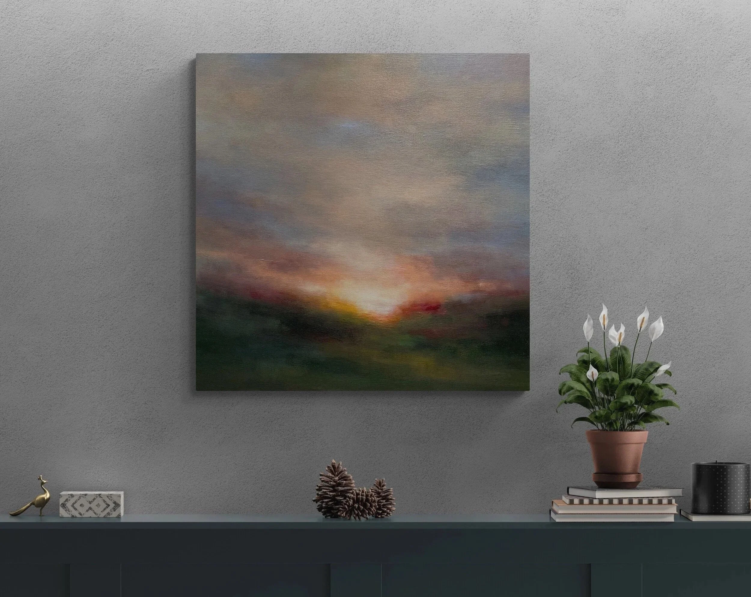 Canvas hanging on wall above shelve above books and plant