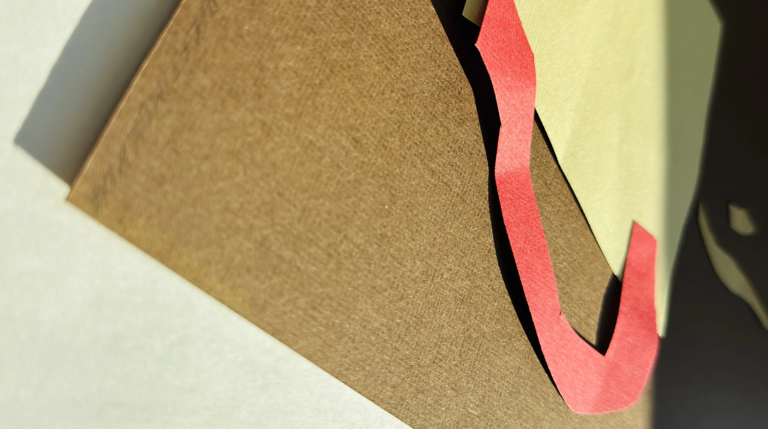 Close-up of layered paper collage edges, showcasing tactile depth and clean hand-cut precision.