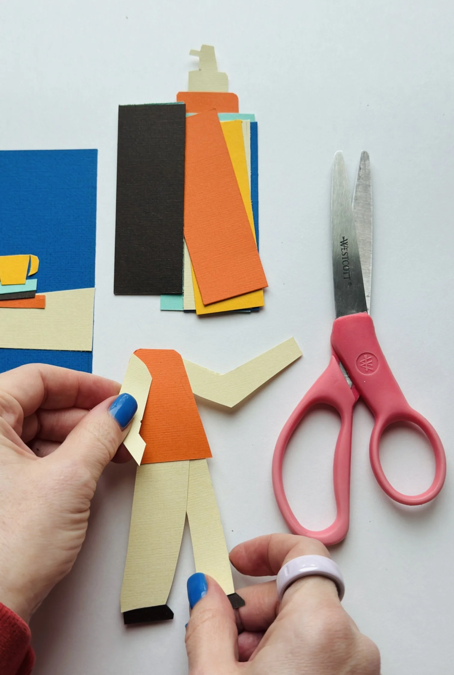 Close-up of Veronika Timokhina’s hands cutting paper layers, demonstrating the artisan handcrafted process behind each illustration