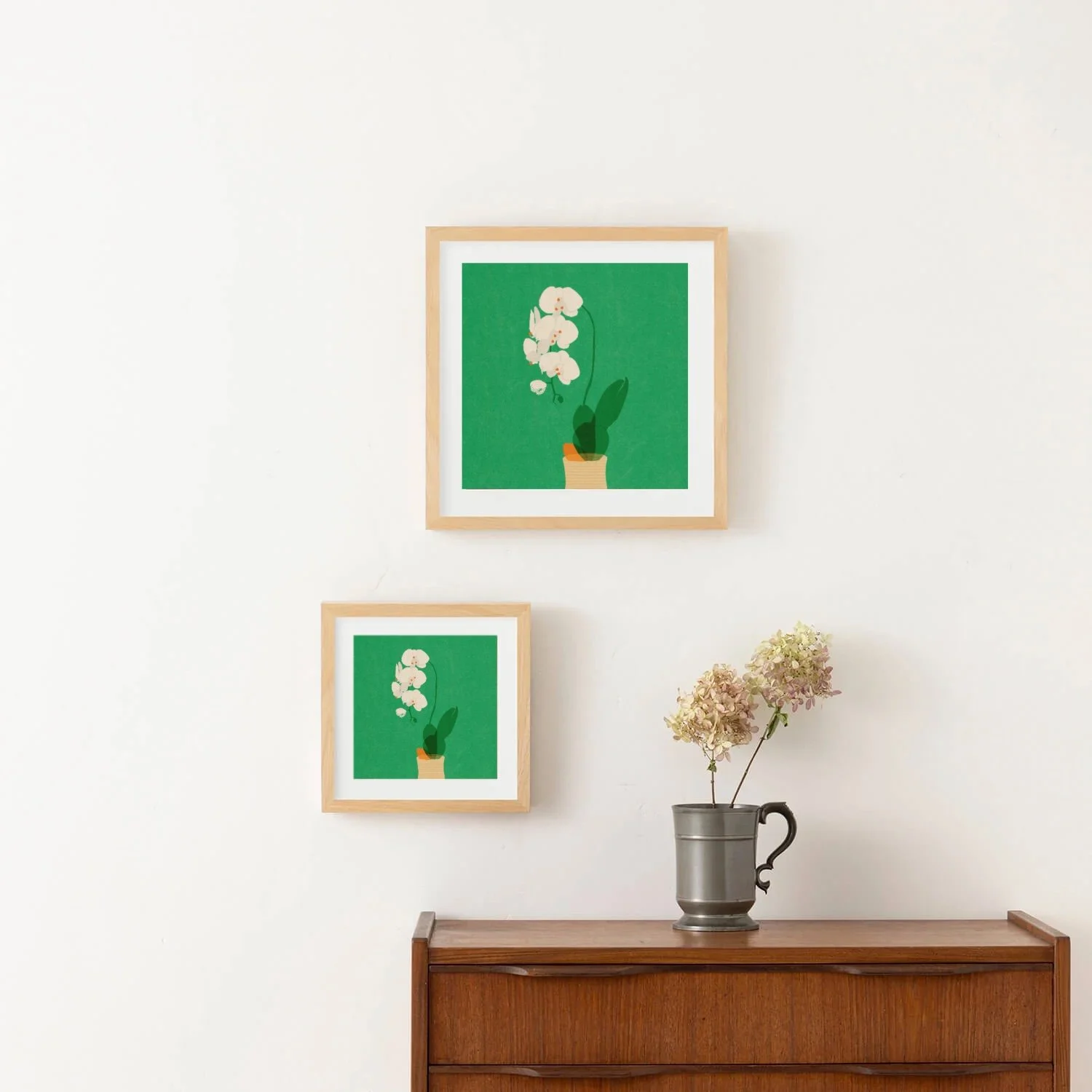 Framed illustration of a white orchid in a striped ceramic pot on a wooden table with a vibrant green background in interior