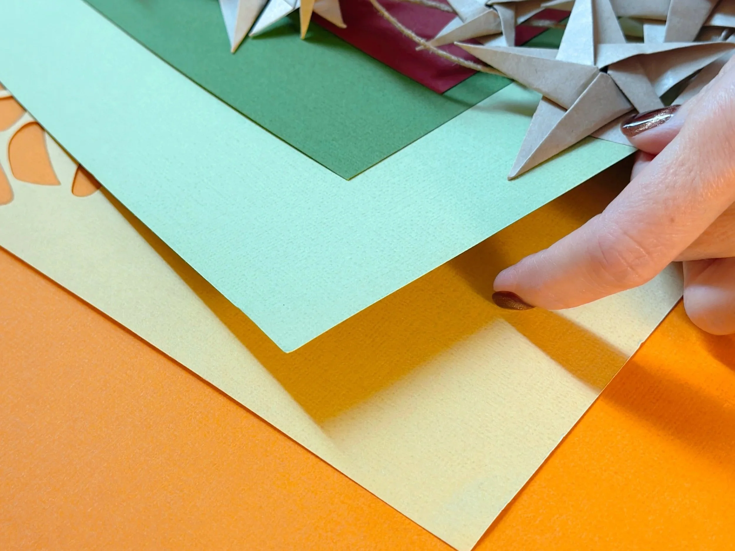 Close-up of layered hand-cut paper — texture, depth, and shadow detail.