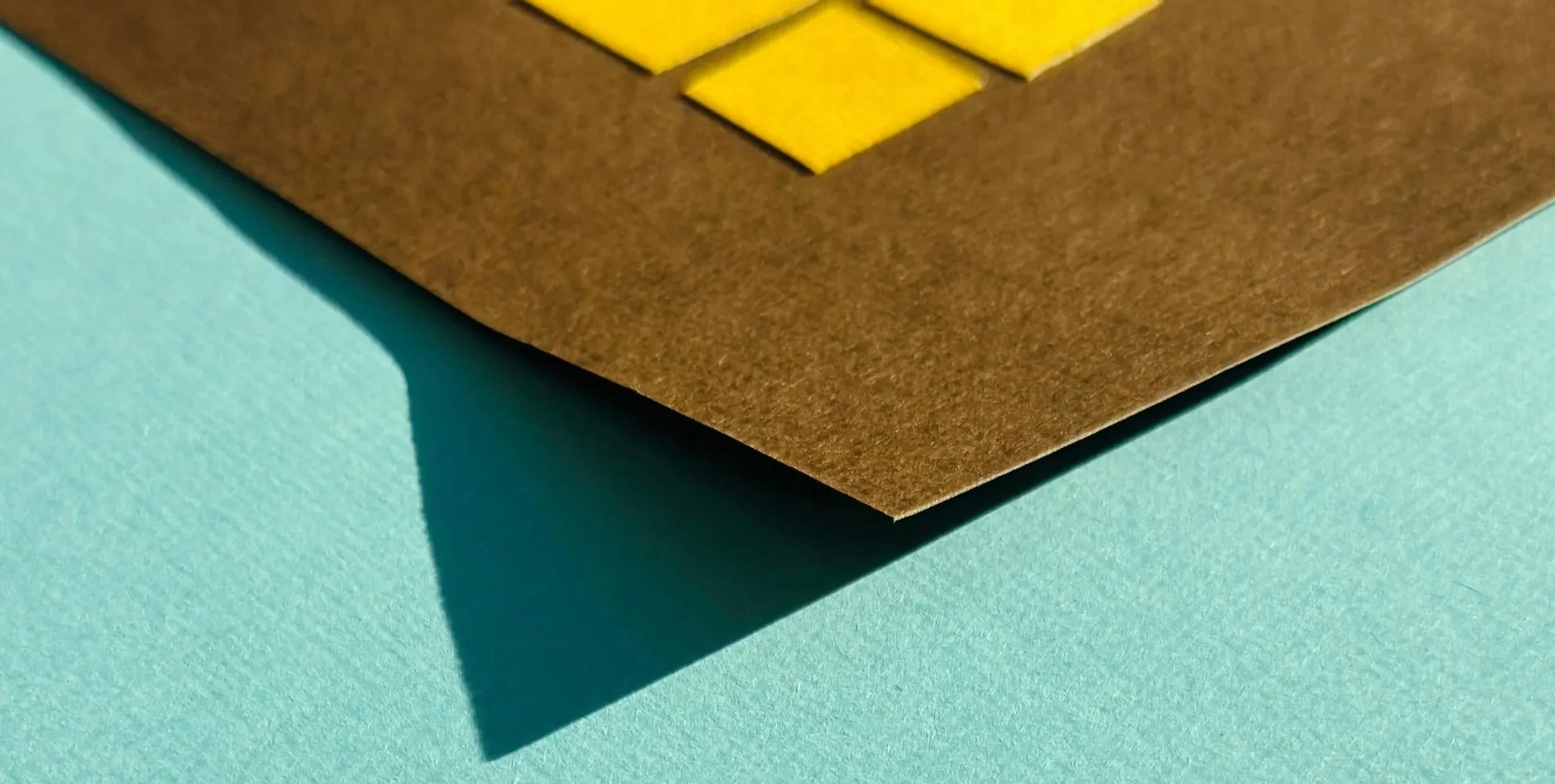 Close-up of layered paper collage edges, showcasing tactile depth and clean hand-cut precision.