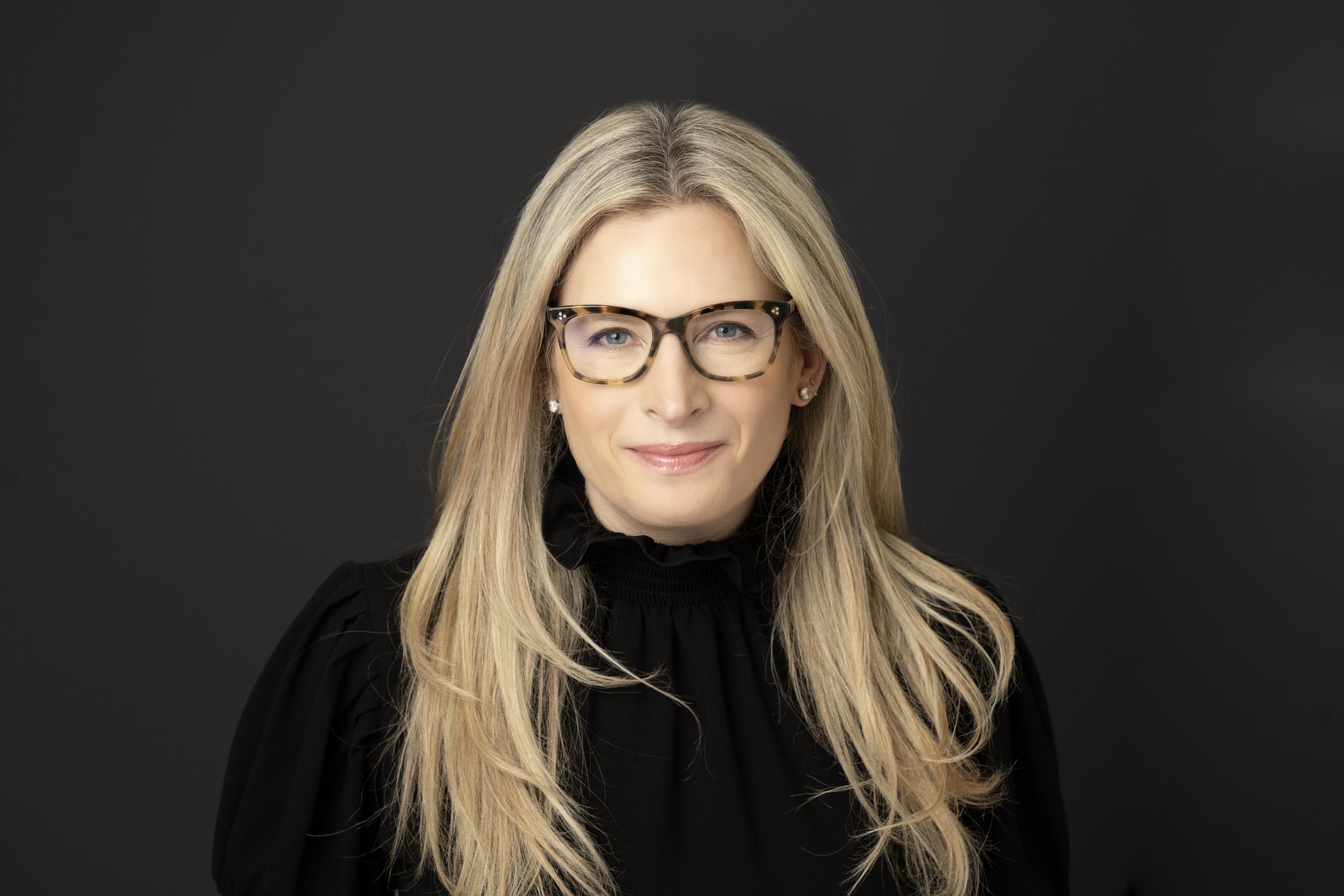 professional corporate headshot on a gray backdrop of a female business woman. She is an executive at a Chicago management consulting firm in the Willis Tower