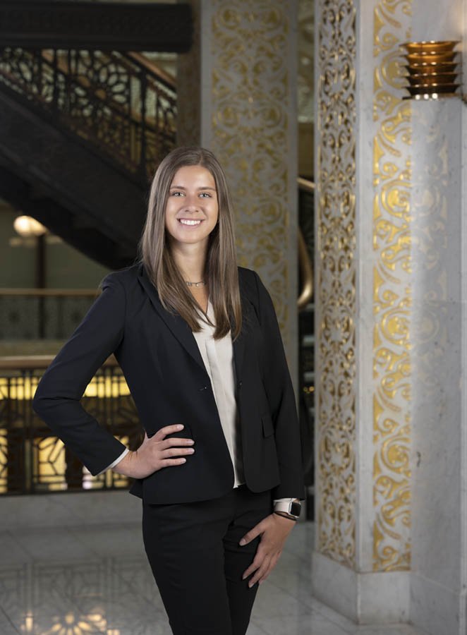 Chicago portrait photography of an attorney taken at the iconic Rookery building. Their law office is in the building. This woman is dressed in professional attire with her hand on her hip.