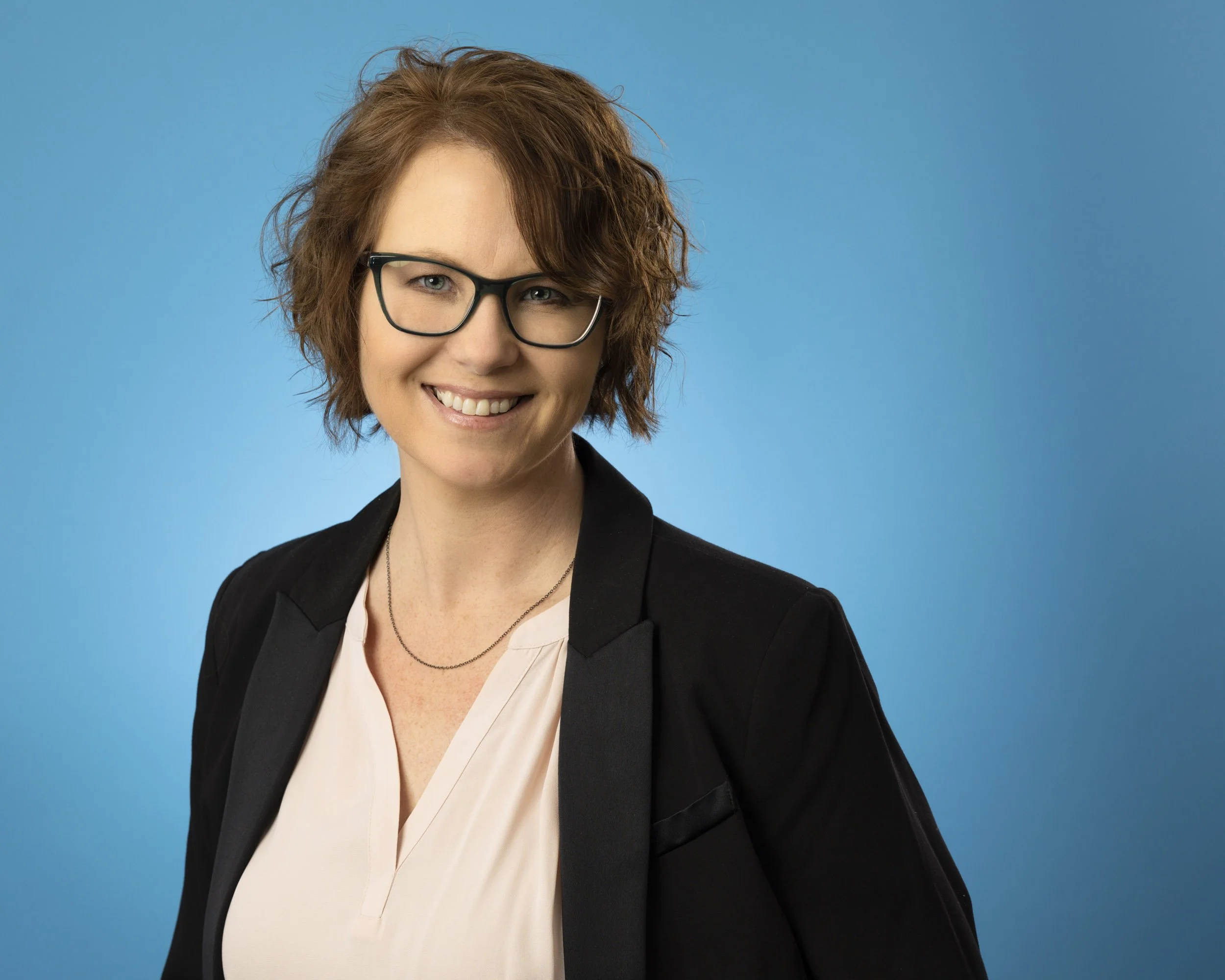 Headshot on a blue background of a hospitality professional