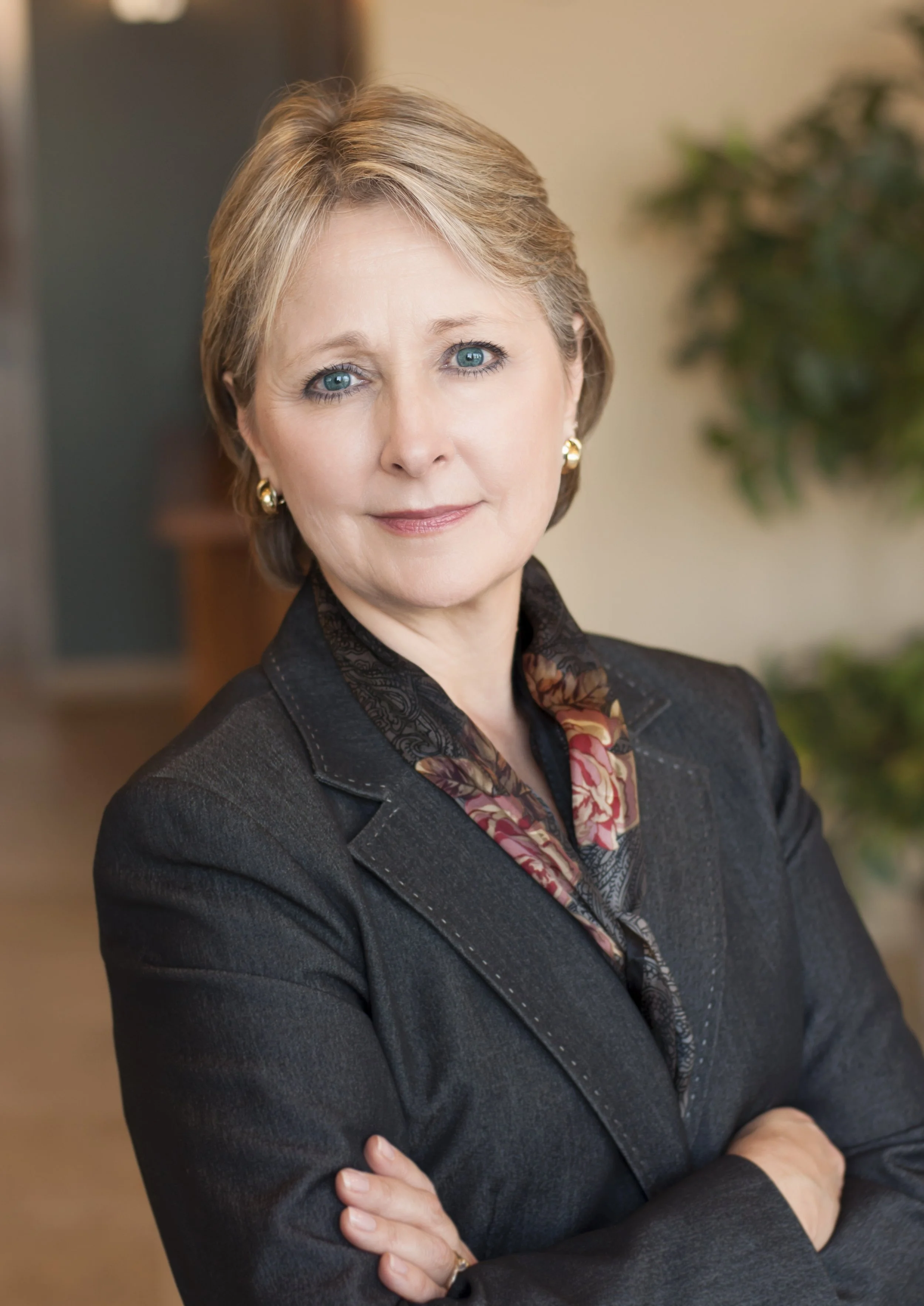 Portrait of a consultant by one of the best Chicago photographers. This woman has a modern look with her arms crossed and her office behind her in the photo. An environmental portrait of a woman.