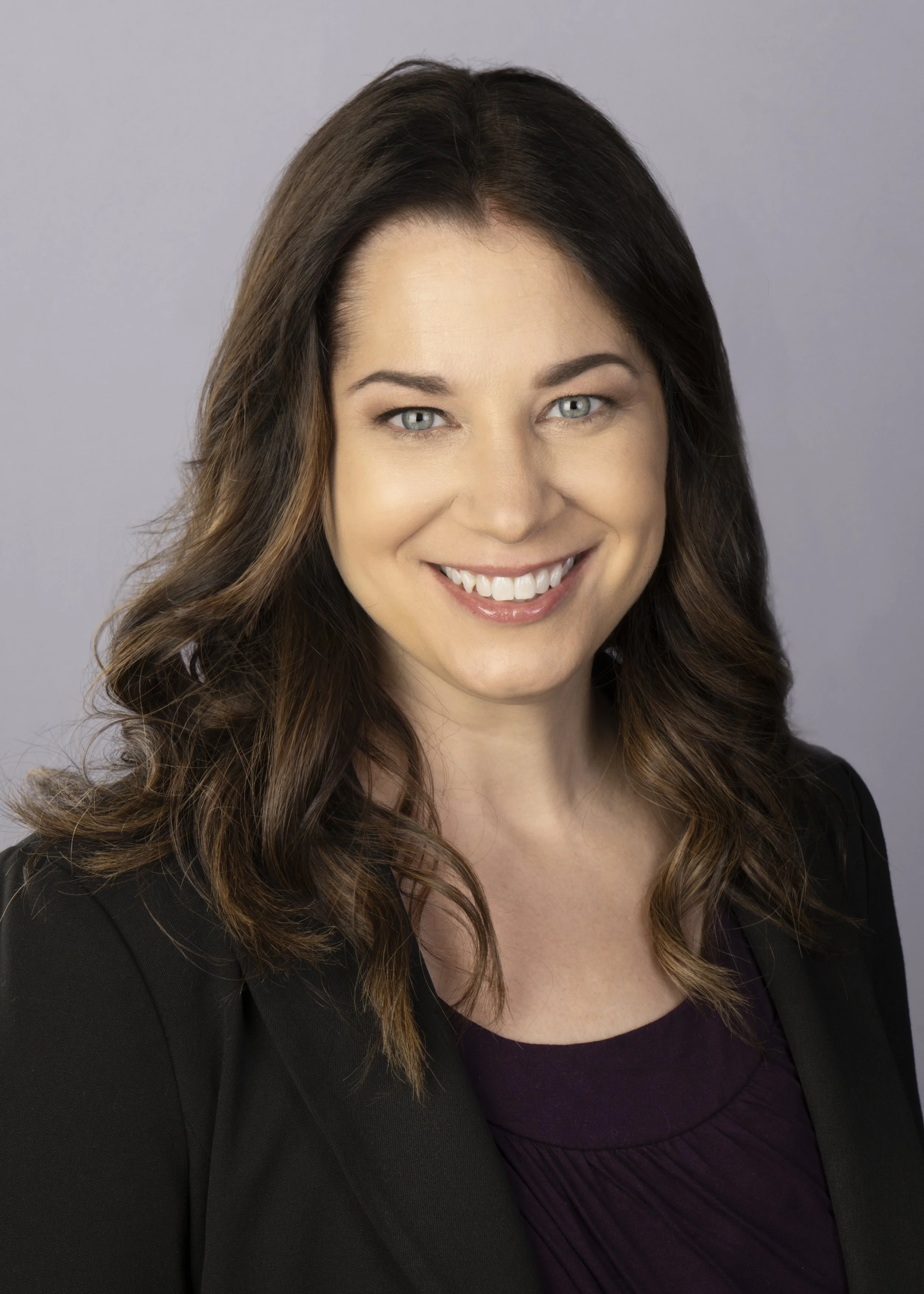 Corporate headshot in Chicago on a light grey background. This executive is the CEO for a large company and is wearing black clothing.