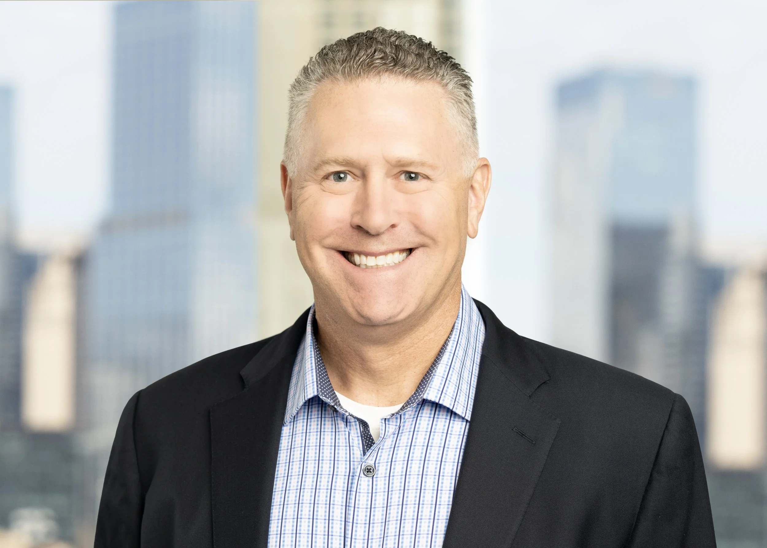 headshot of a Chicago executive CEO against the skyline out of focus background for a high end marketing rebranding