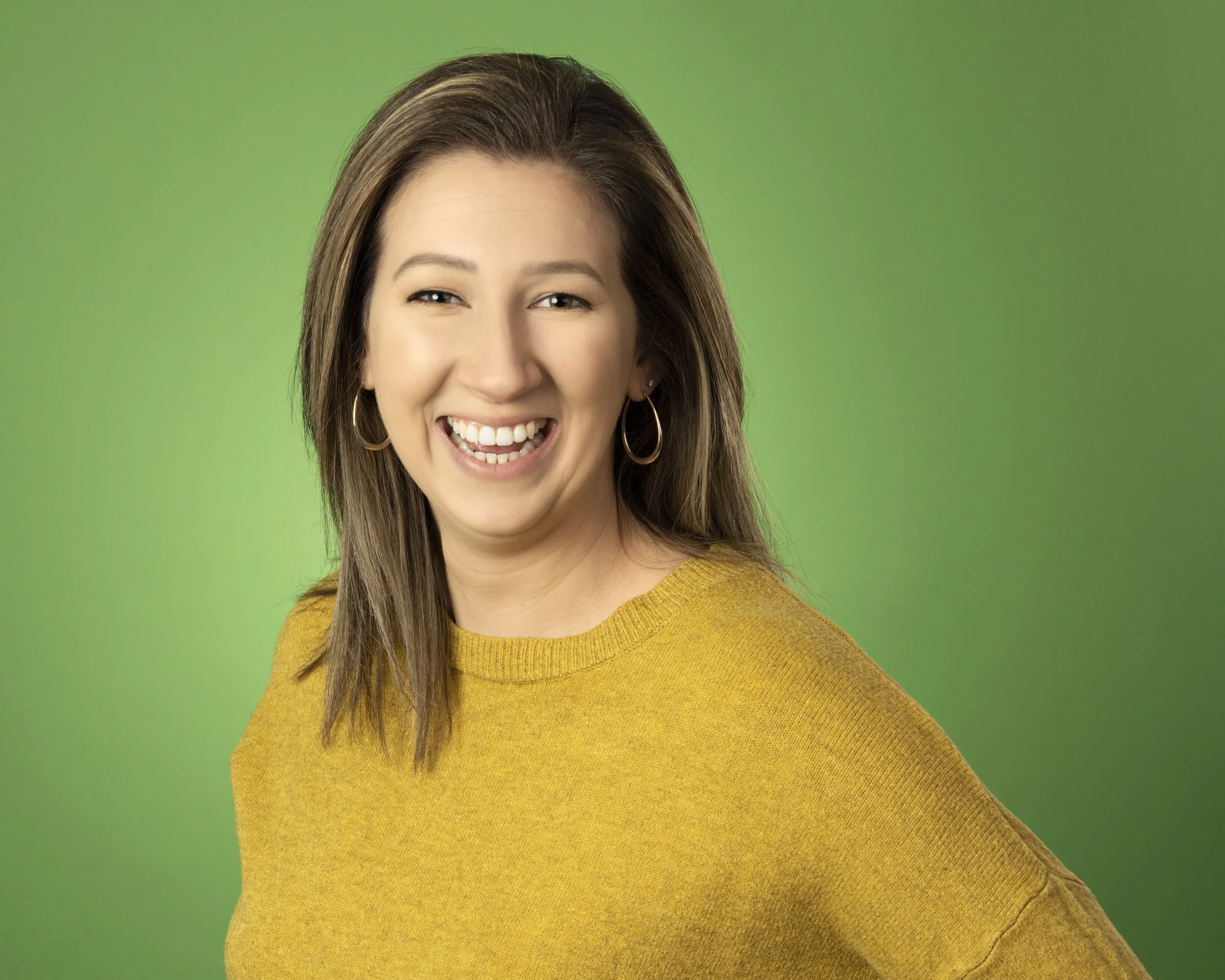 Headshot for a hospitality marketing company in Chicago against a green backdrop