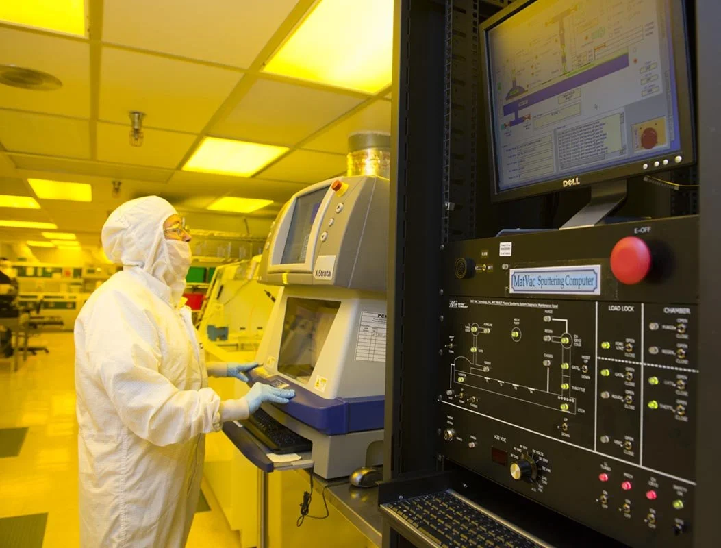 Laboratory scientist in protective gear working with scientific equipment in a Clean Room environment.
