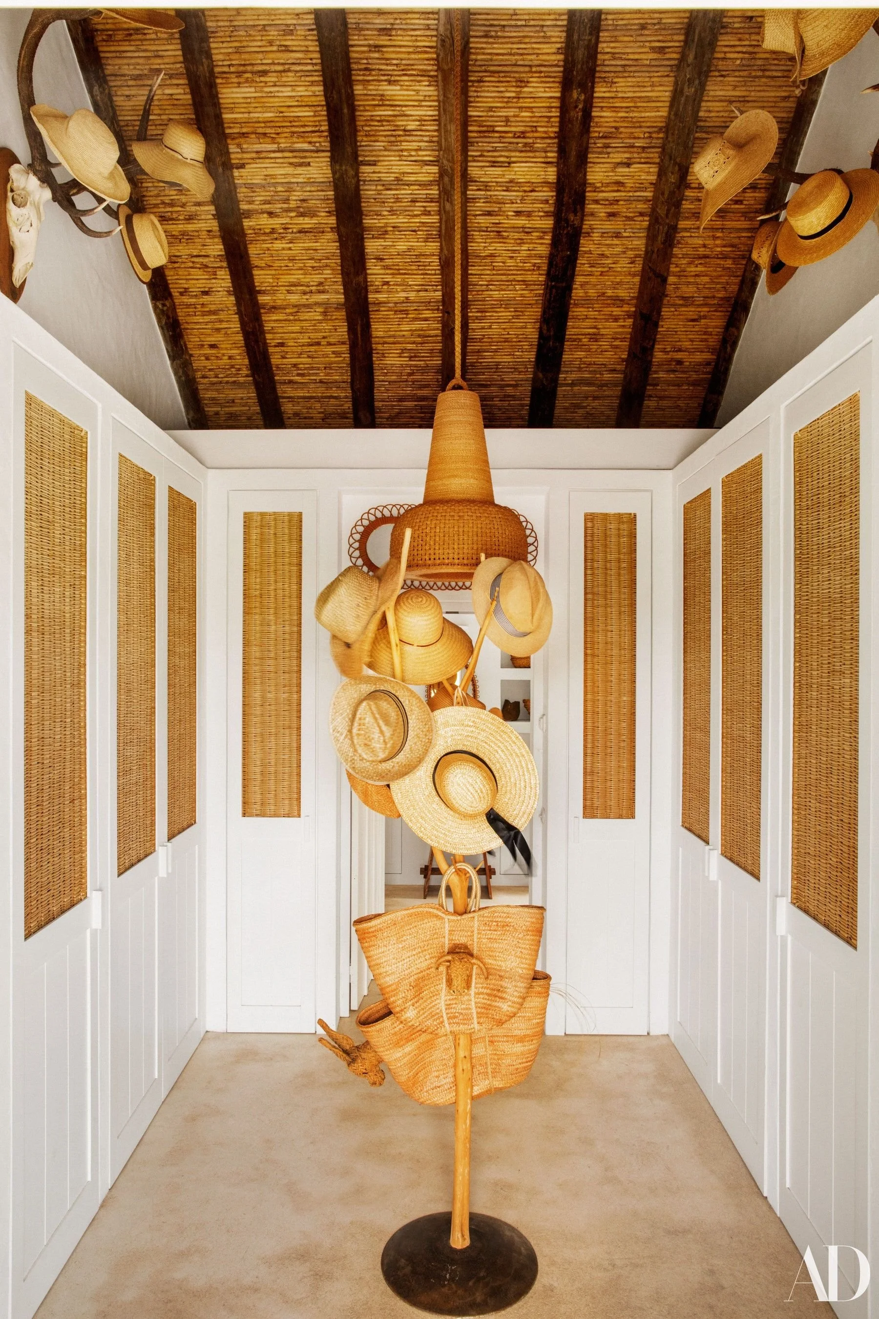 A hat rack and hats hanging from animal horns as wall decor in walk-in closet of Patrick Perrin compound in Portugal