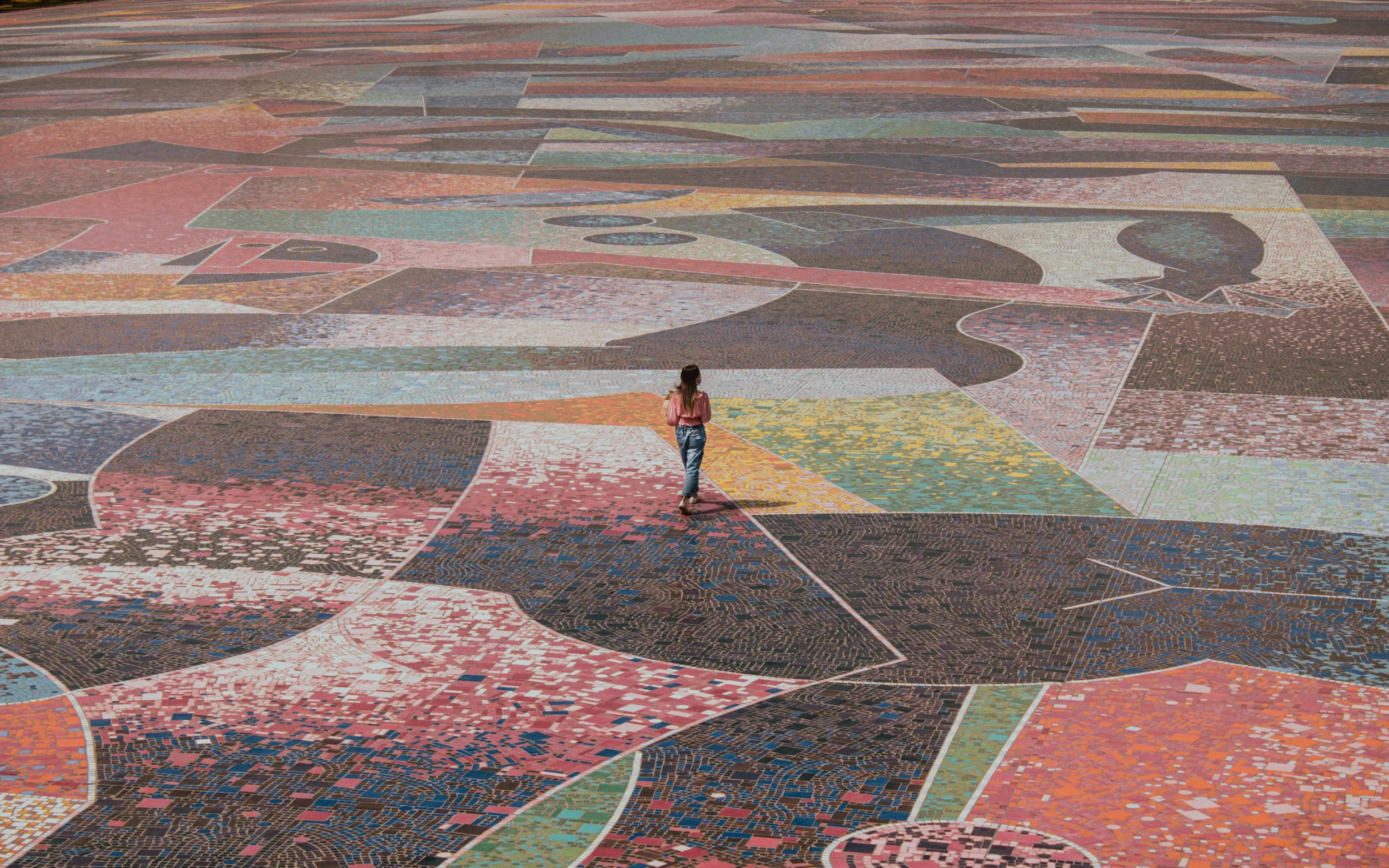 woman walking across floor of a large abstract image