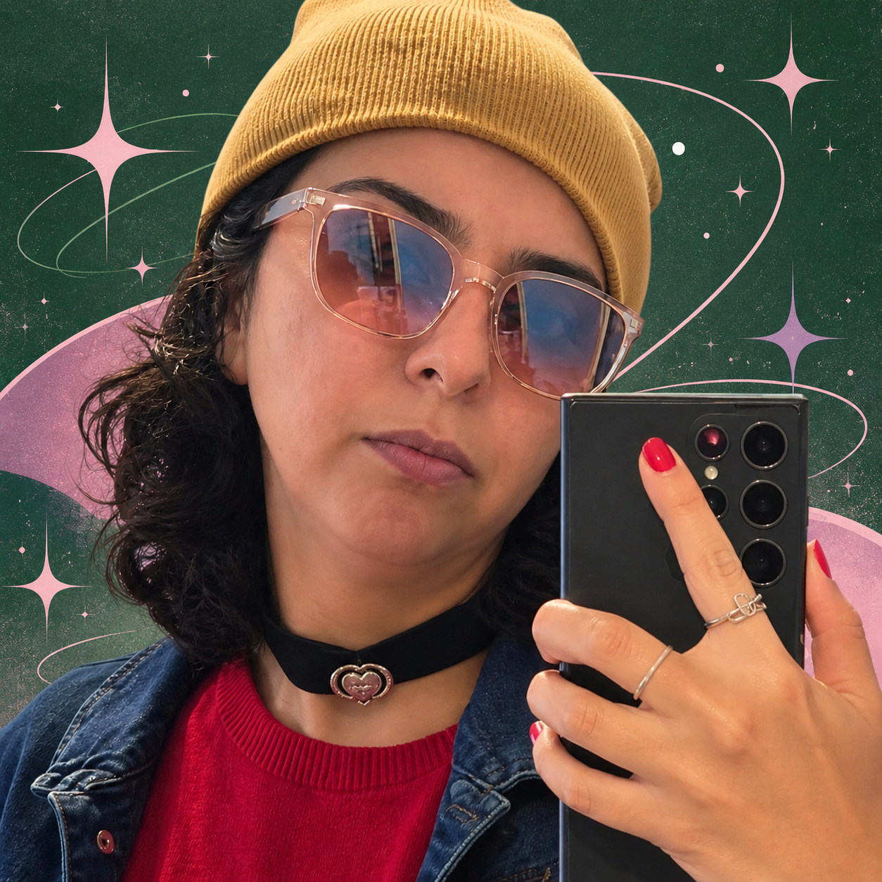 Natalie V Garcia in a mustard beanie and tinted glasses, taking a mirror selfie against a starry background.