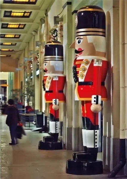 Monumental handcrafted nutcracker sculptures towering above visitors inside the historic CityLink arcade in Athens, part of an immersive experiential installation by Studio Vourli.