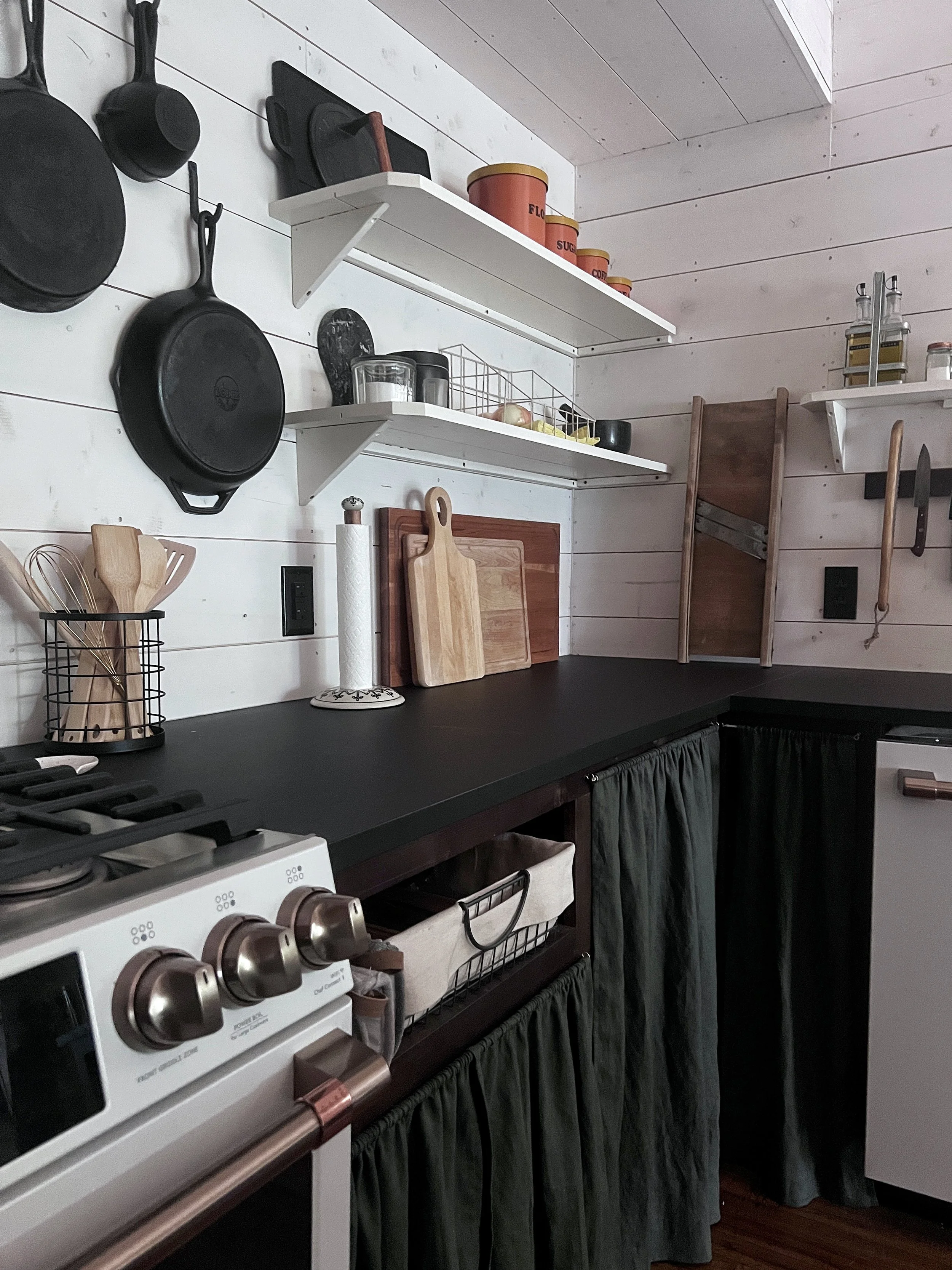 Multiple storage options for a vintage styled kitchen with open shelving and wall hooks