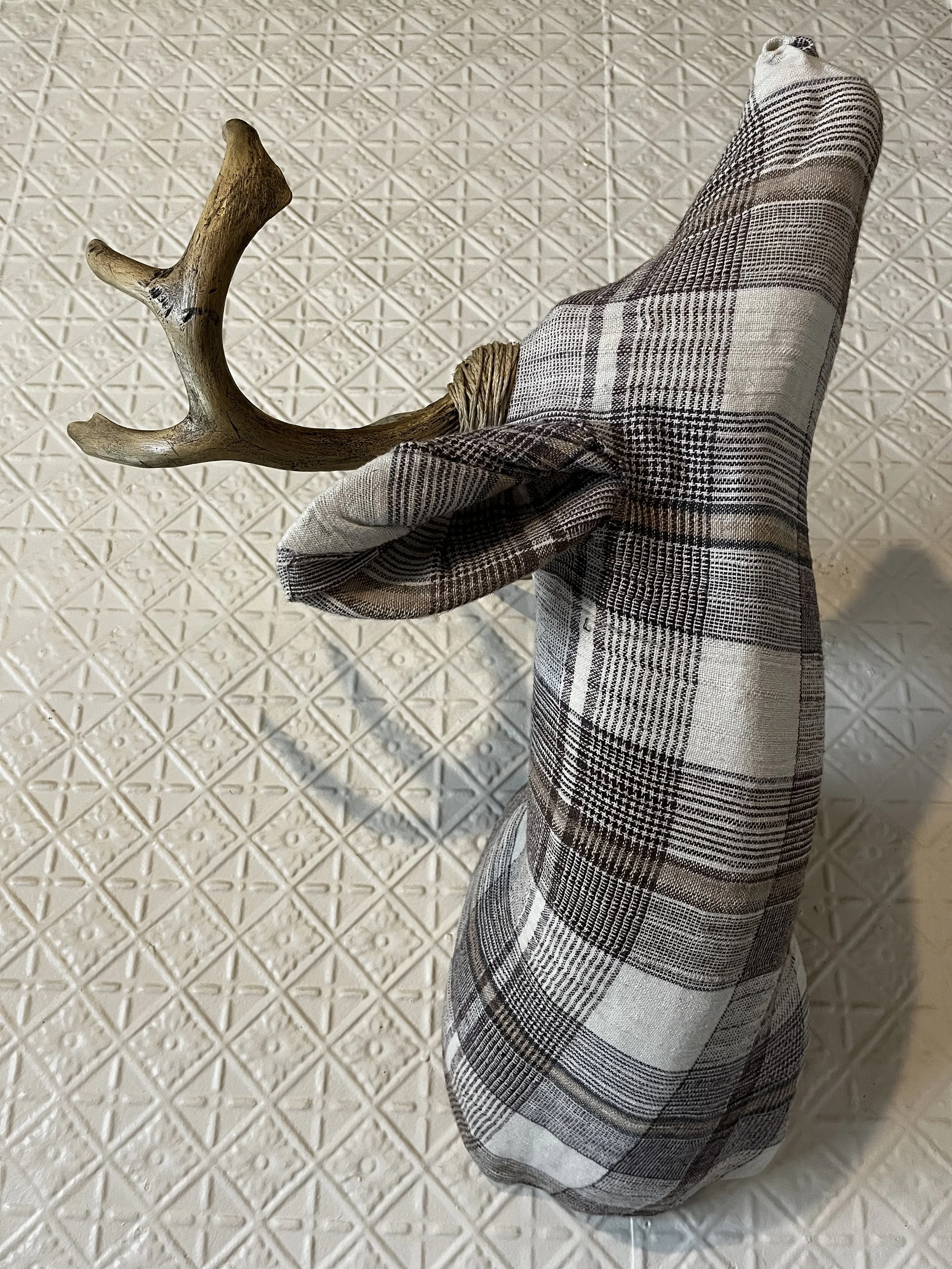 Plaid fabric deer head with antlers on a textured background