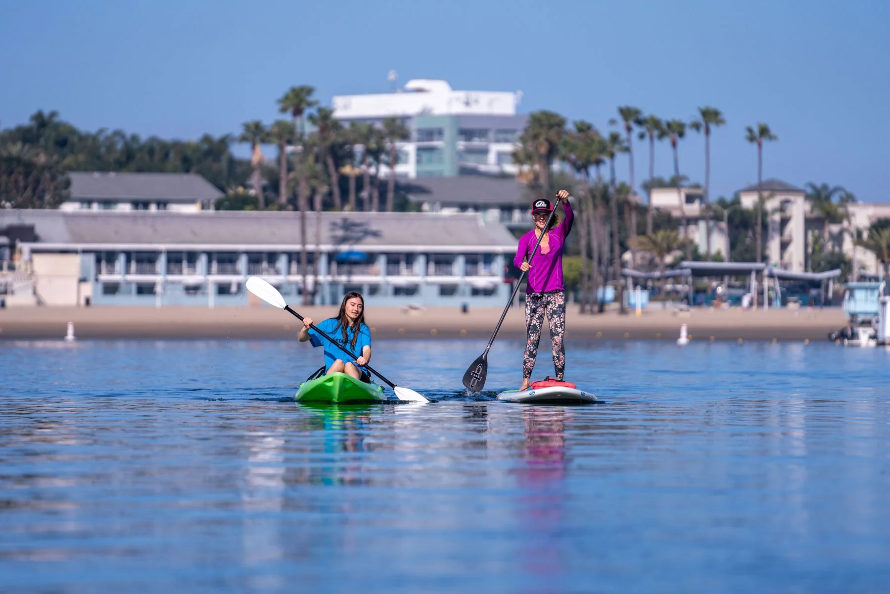 photo by Brandon Kirk of a kayaker and stand up paddleboarder on Mother's Beach, Marina del rey