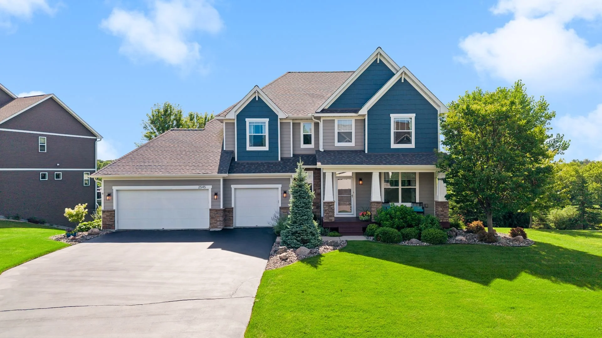 Two-story home with blue and gray siding and a three-car garage in Lakebridge, Victoria, MN