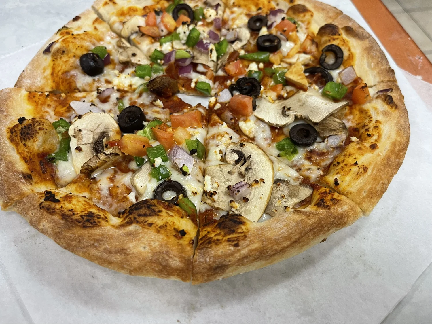 Dubai Grills pizza topped with vegetables and melted cheese