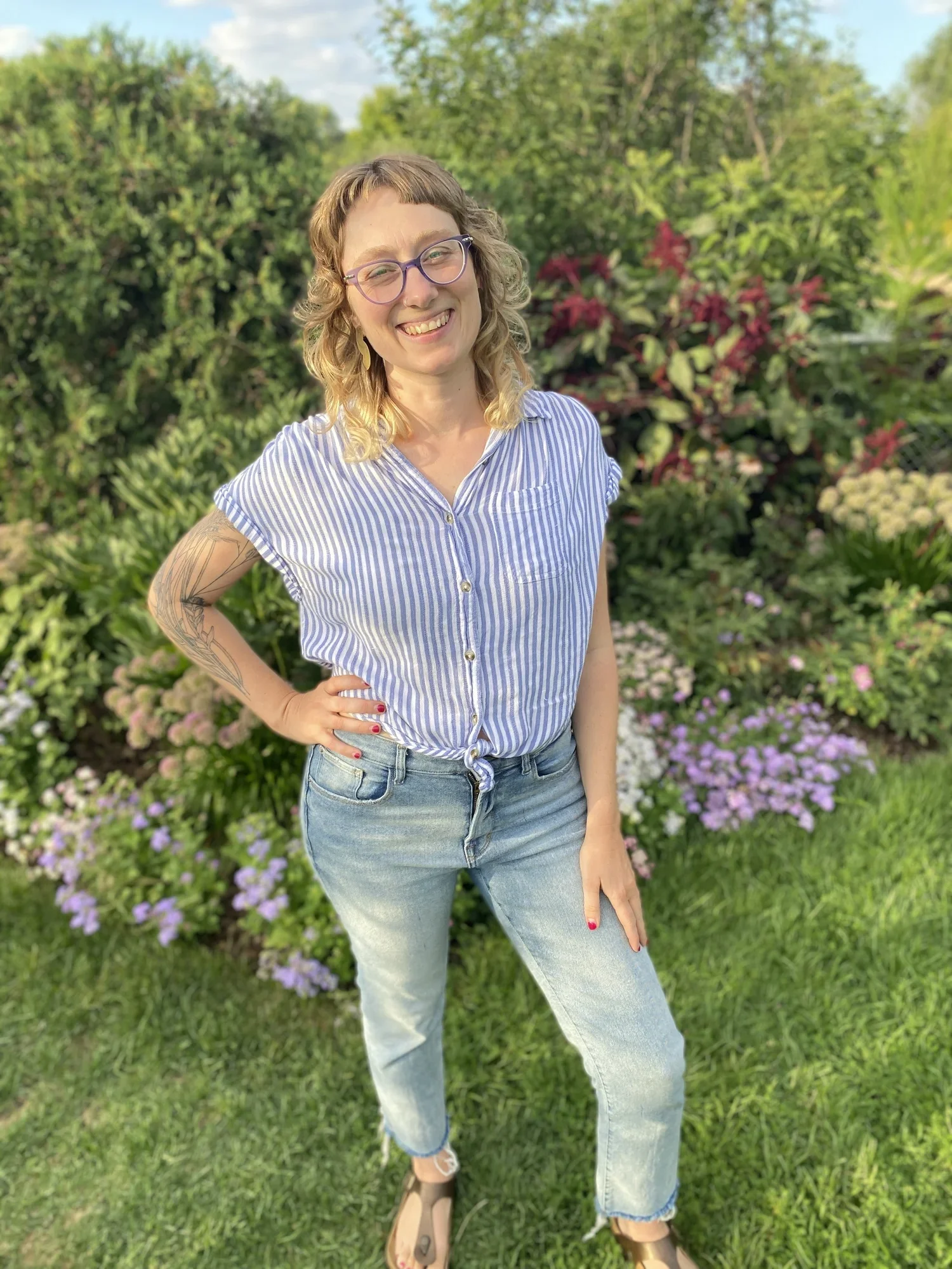 Sarah smiles with a hand on her hip