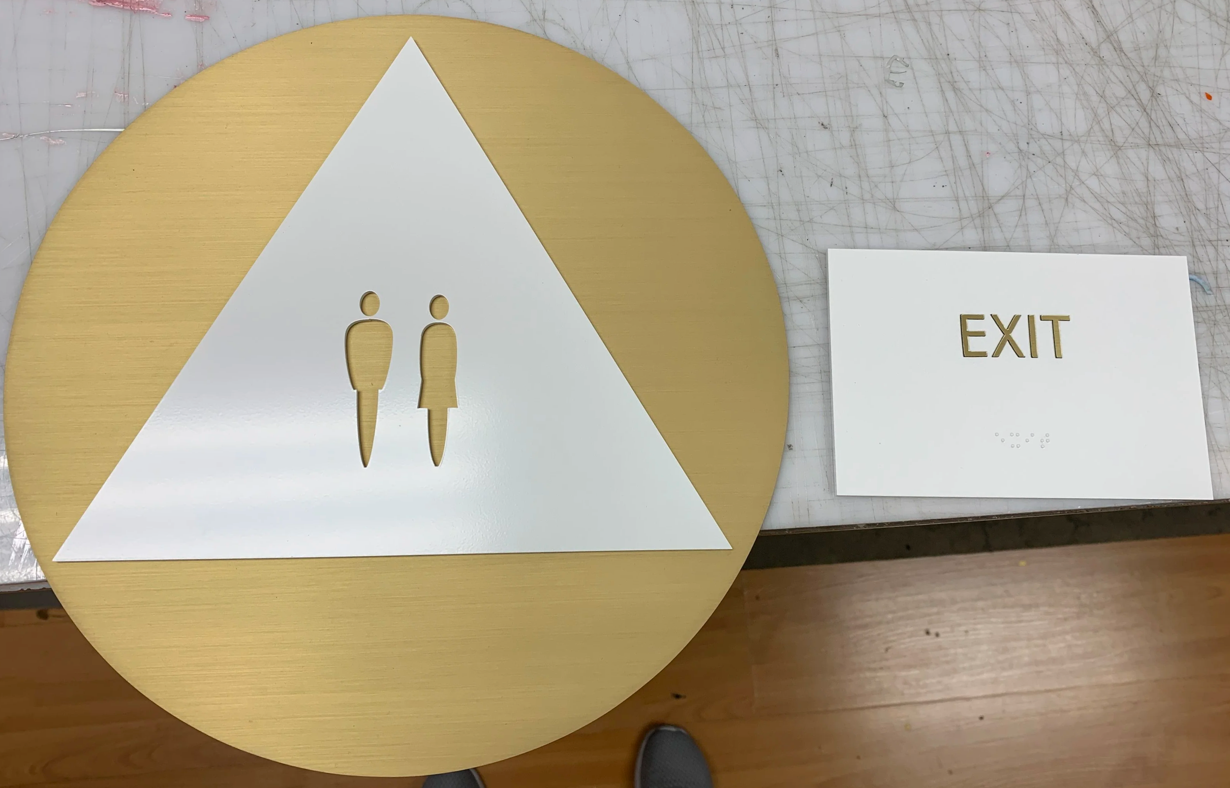 Brass and white restroom and exit sign