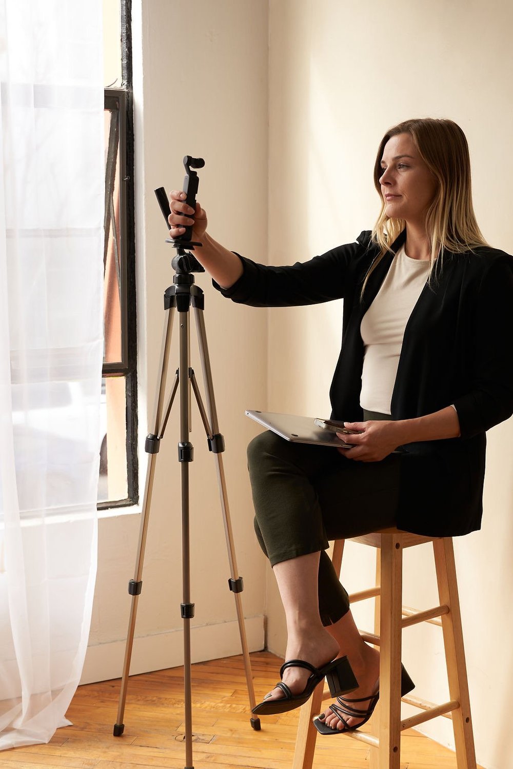 Maddie setting up a camera on a tripod during a content session