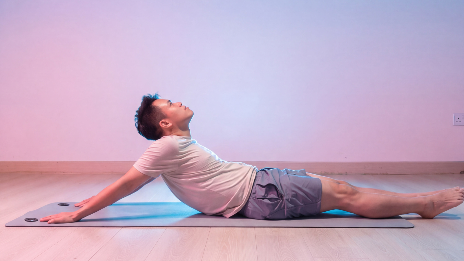 Man performing a seated chest-opening stretch on a yoga mat.