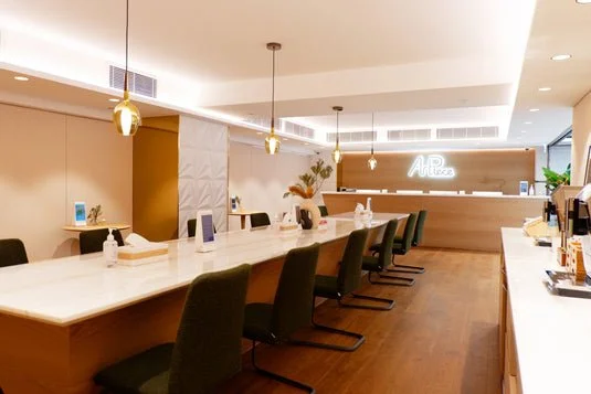 TeamX Art Piece 8/F lounge: Contemporary space with bright lighting and marble tables. Members enjoy complimentary beverages & concierge service while connecting post-class.