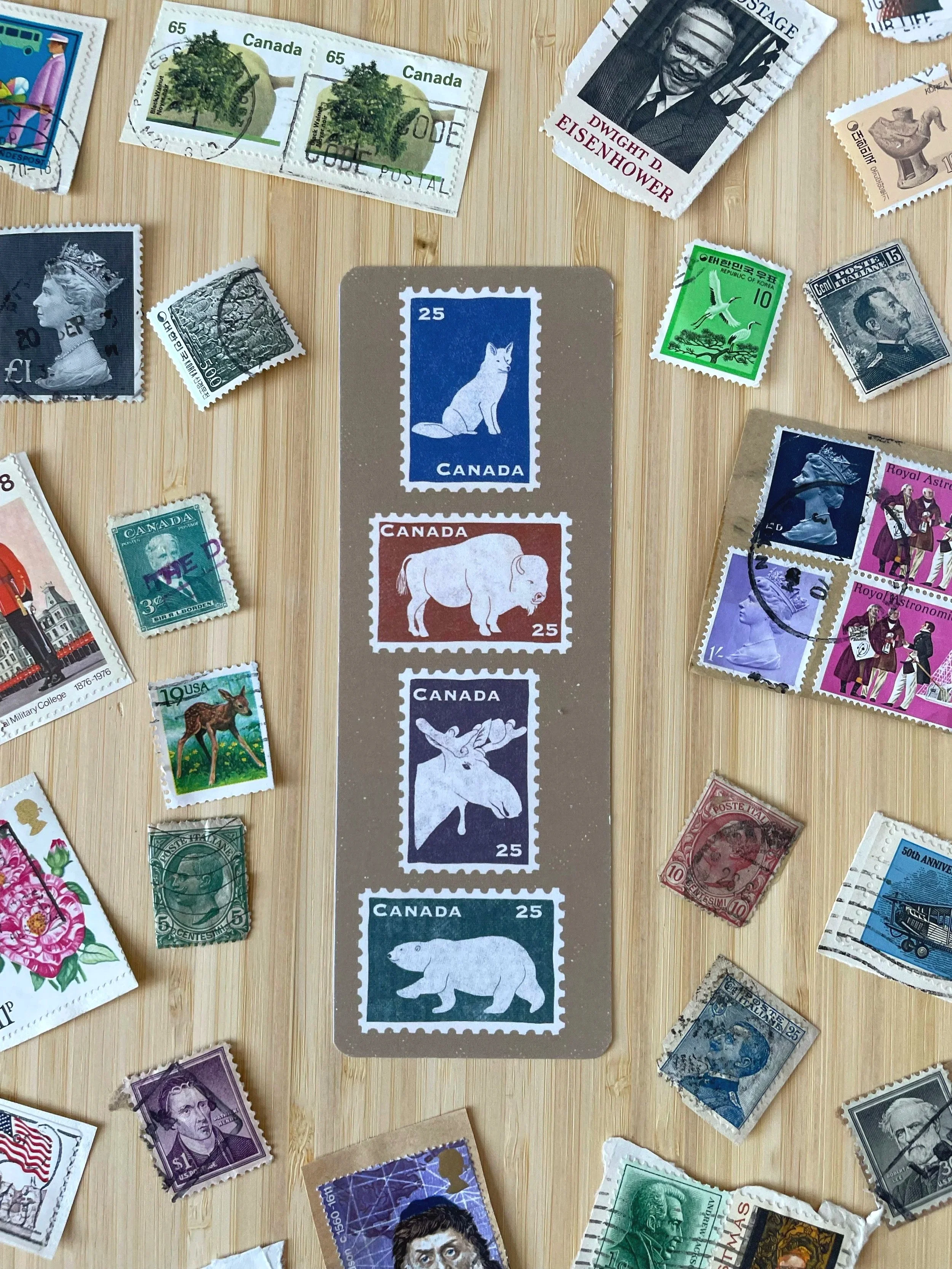 Tan bookmark features 4 iconic Canadian Mammals. The fox, bison moose and polar bear are featured on vintage style stamps.