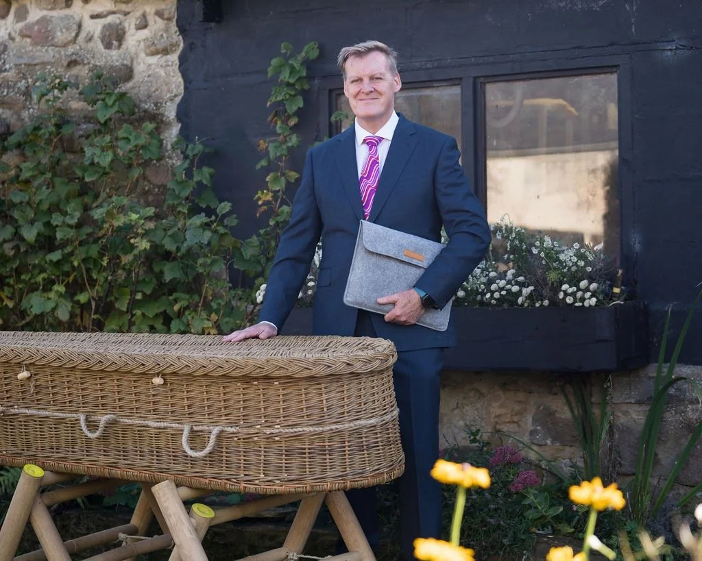 David Moon with a wicker coffin conducting an outdoor eco funeral