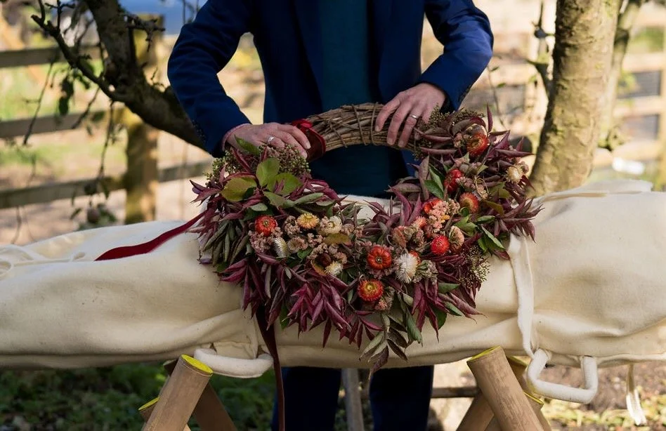 Guest helps prepare flower tribute at inclusive and participative eco funeral