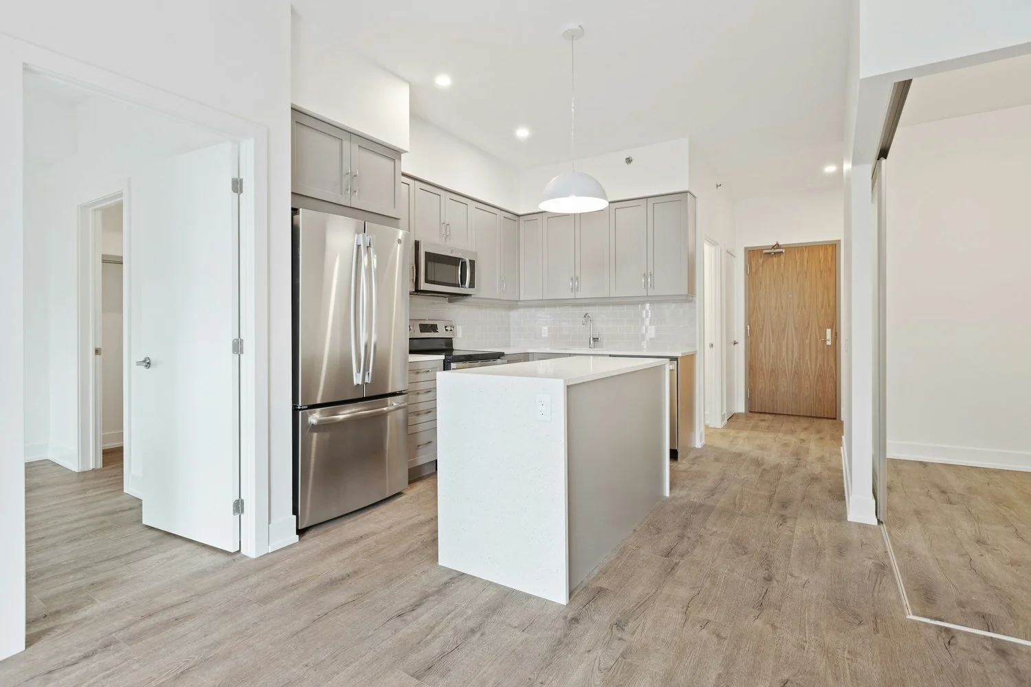 Open concept kitchen with natural wood floors, center kitchen island, and Viking stainless steel appliances