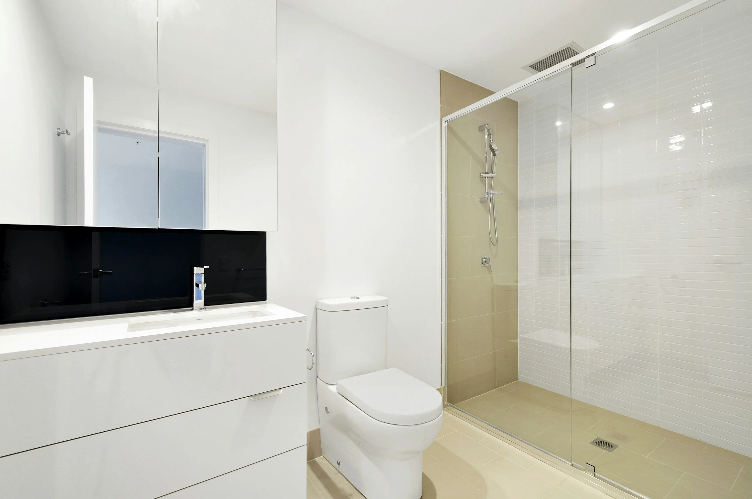 Modern bathroom with shower, white vanity, marble countertops, and blonde bamboo wood flooring