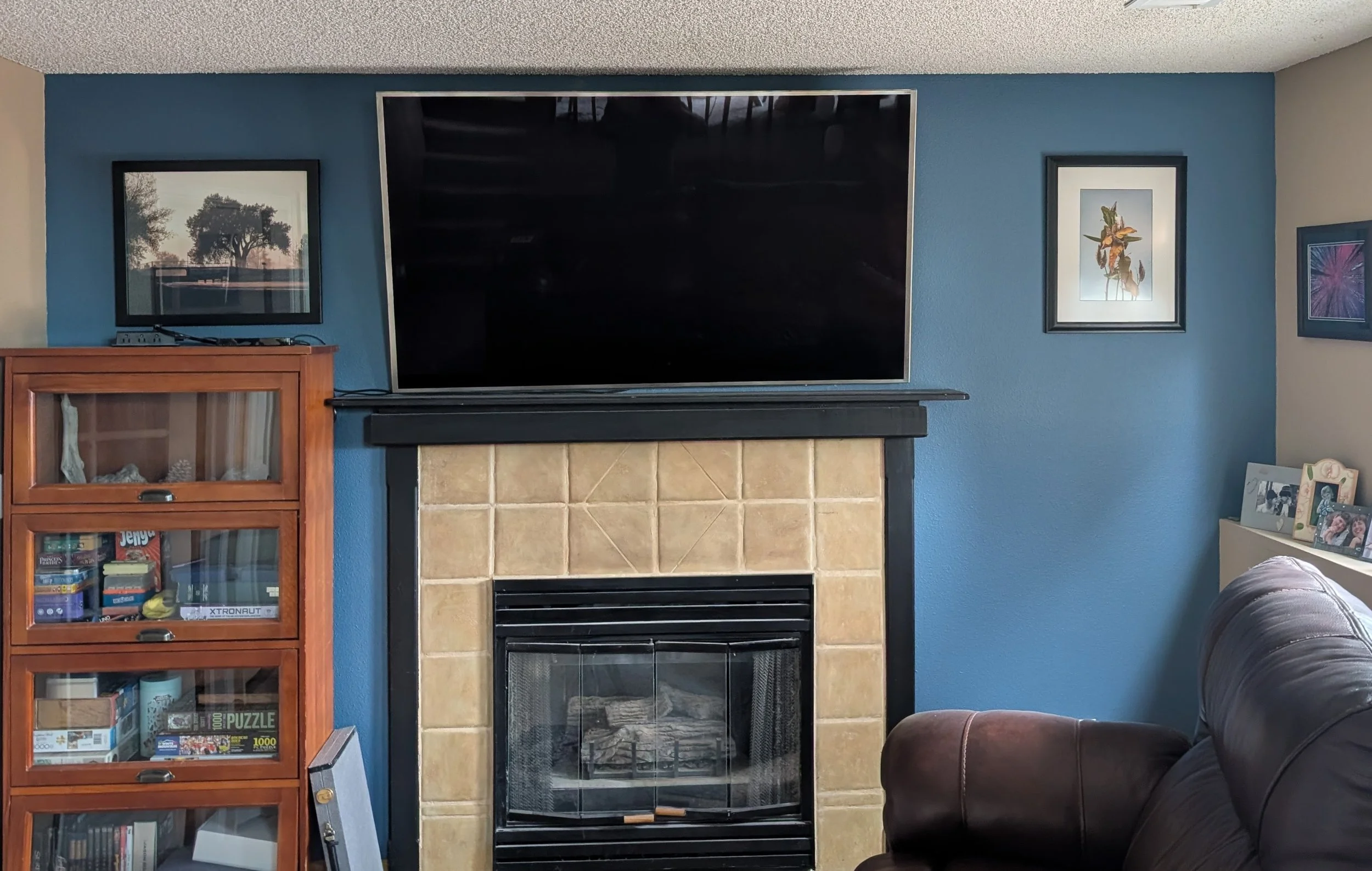 Photo of Fireplace with prints hanging on the wall.