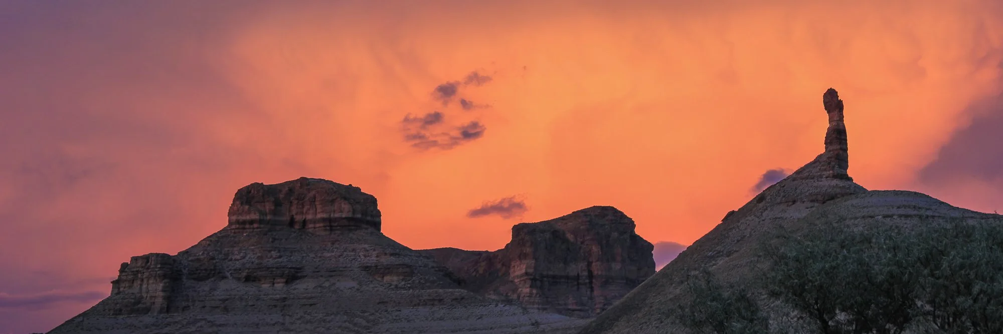 Photo of Buttes and Needles near the green river in Colorado at sunrise with orange light diffused by clouds