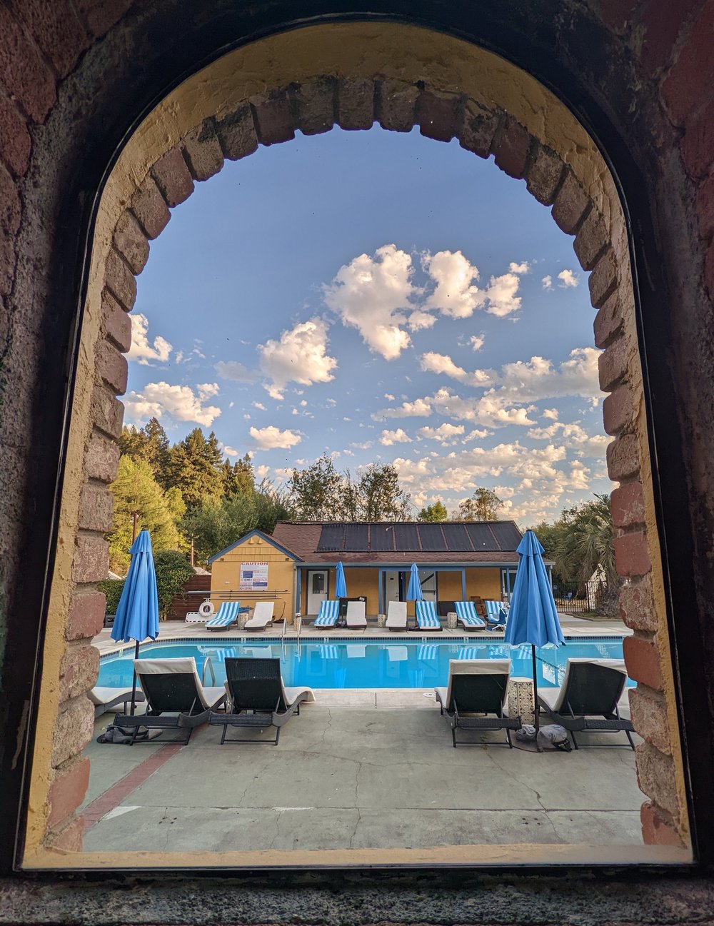 The pool framed through an arched window