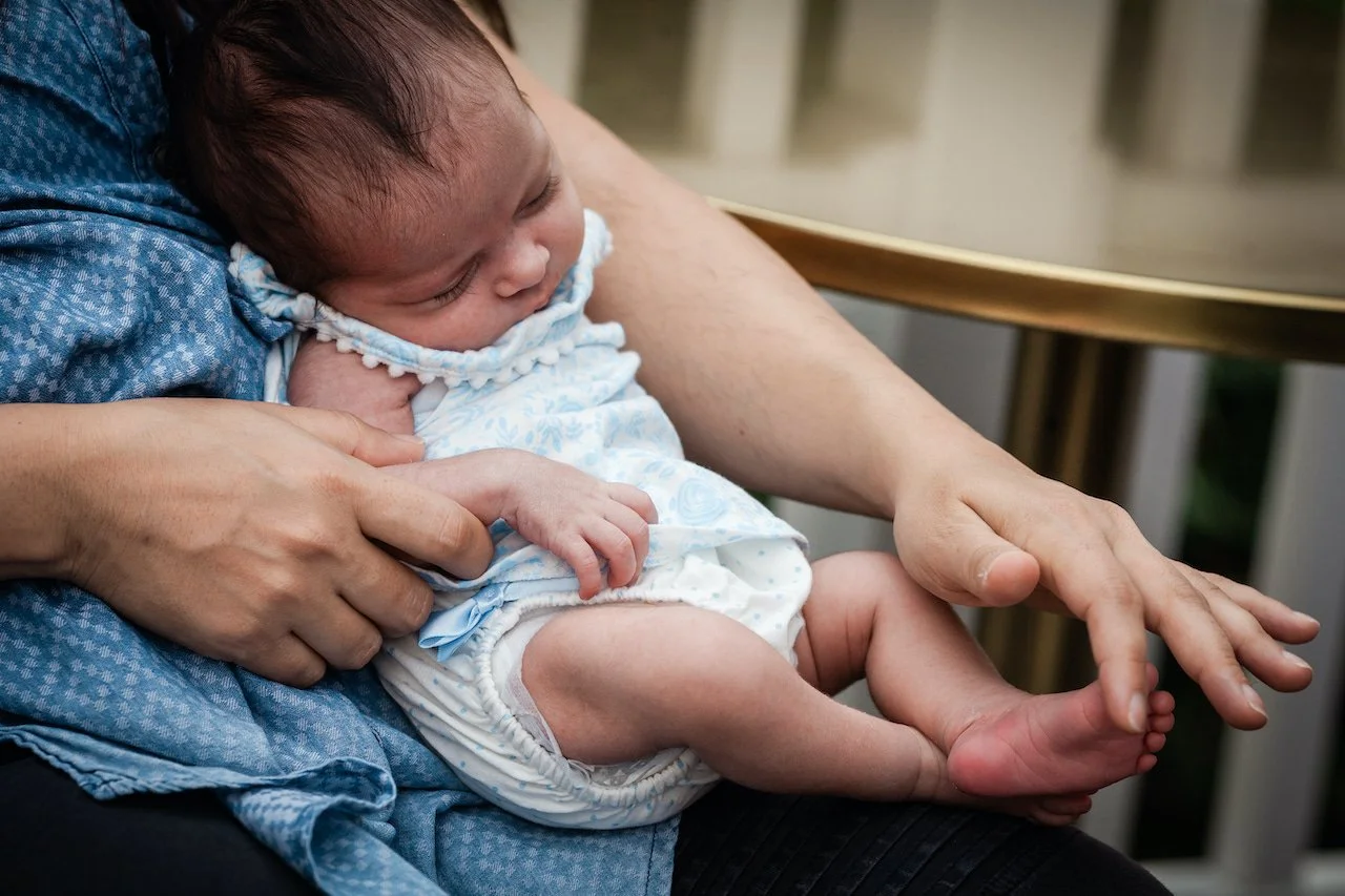 mom-holding-newborn-tickling-foot-documentary-family-photographer-kim-max.jpg