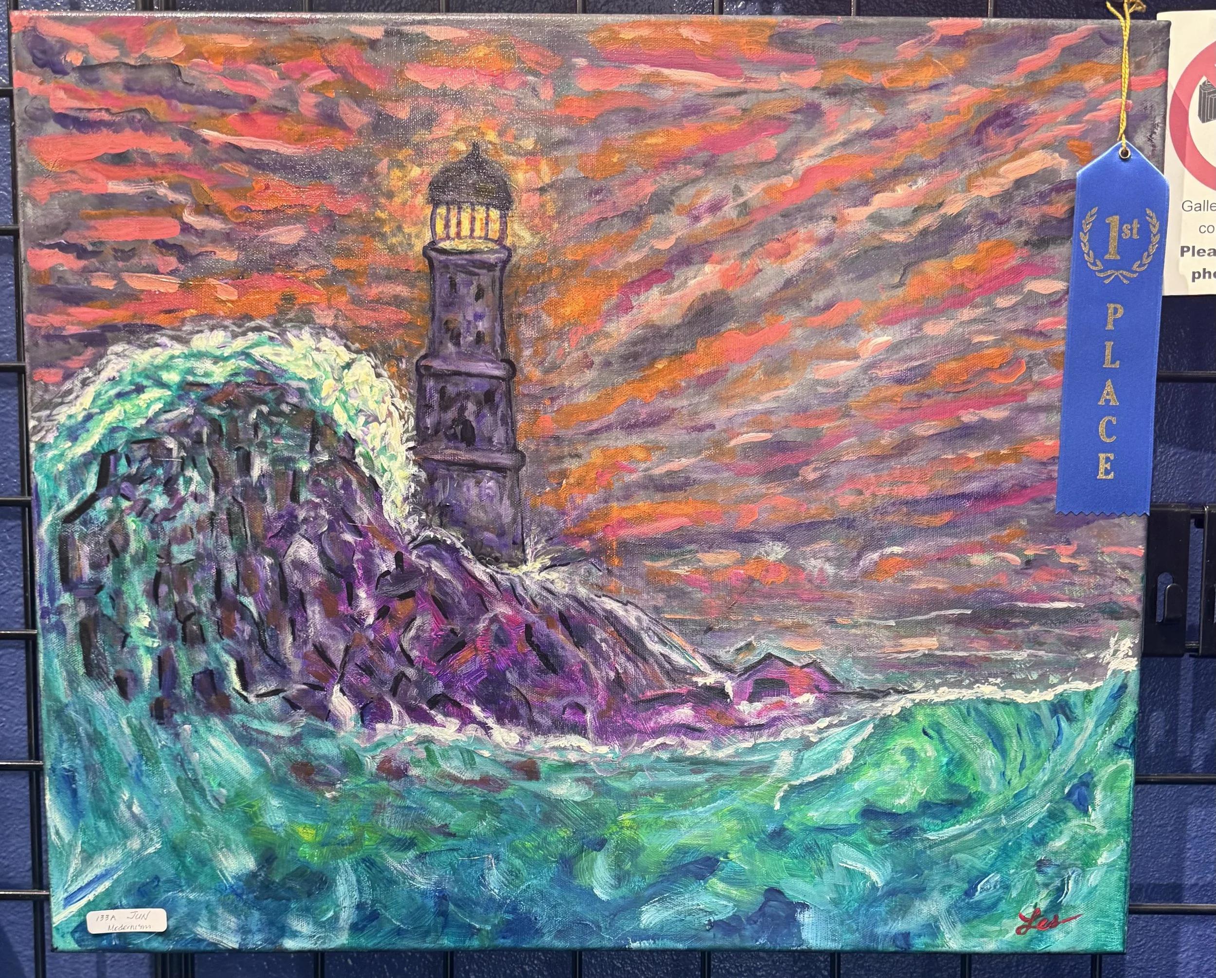 An impressionist painting of a lighthouse against a vibrant, colorful sky with swirling clouds in shades of pink, purple, orange, and blue, with green and purple reflections at the bottom and a blue ribbon that reads '1st Place' attached to the right