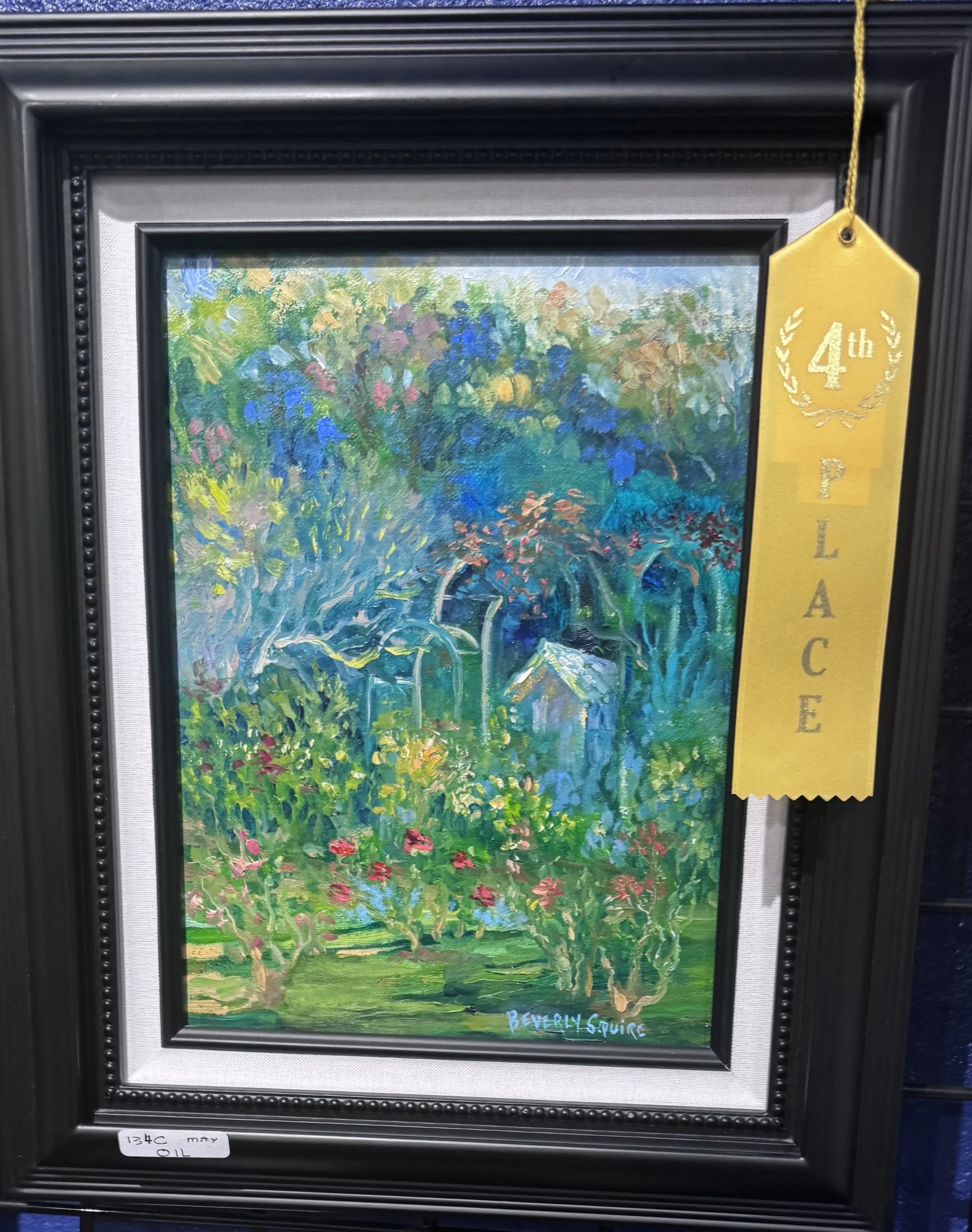 An impressionist painting of a lush garden with vibrant flowers and greenery, framed in black with a silver inner border and a yellow ribbon indicating a 4th place award.