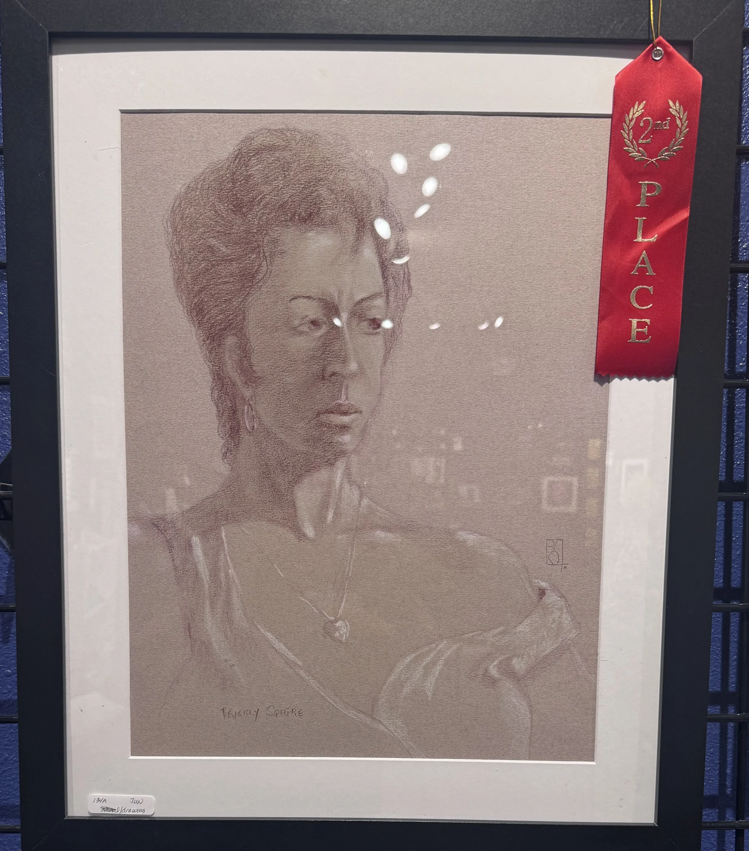 A framed sketch of a squirrel printed on textured paper with a red ribbon label indicating second place in an art competition. The note at the bottom of the sketch reads 'Teverly Squirrel' and the lower left corner has a label with the artist's name 