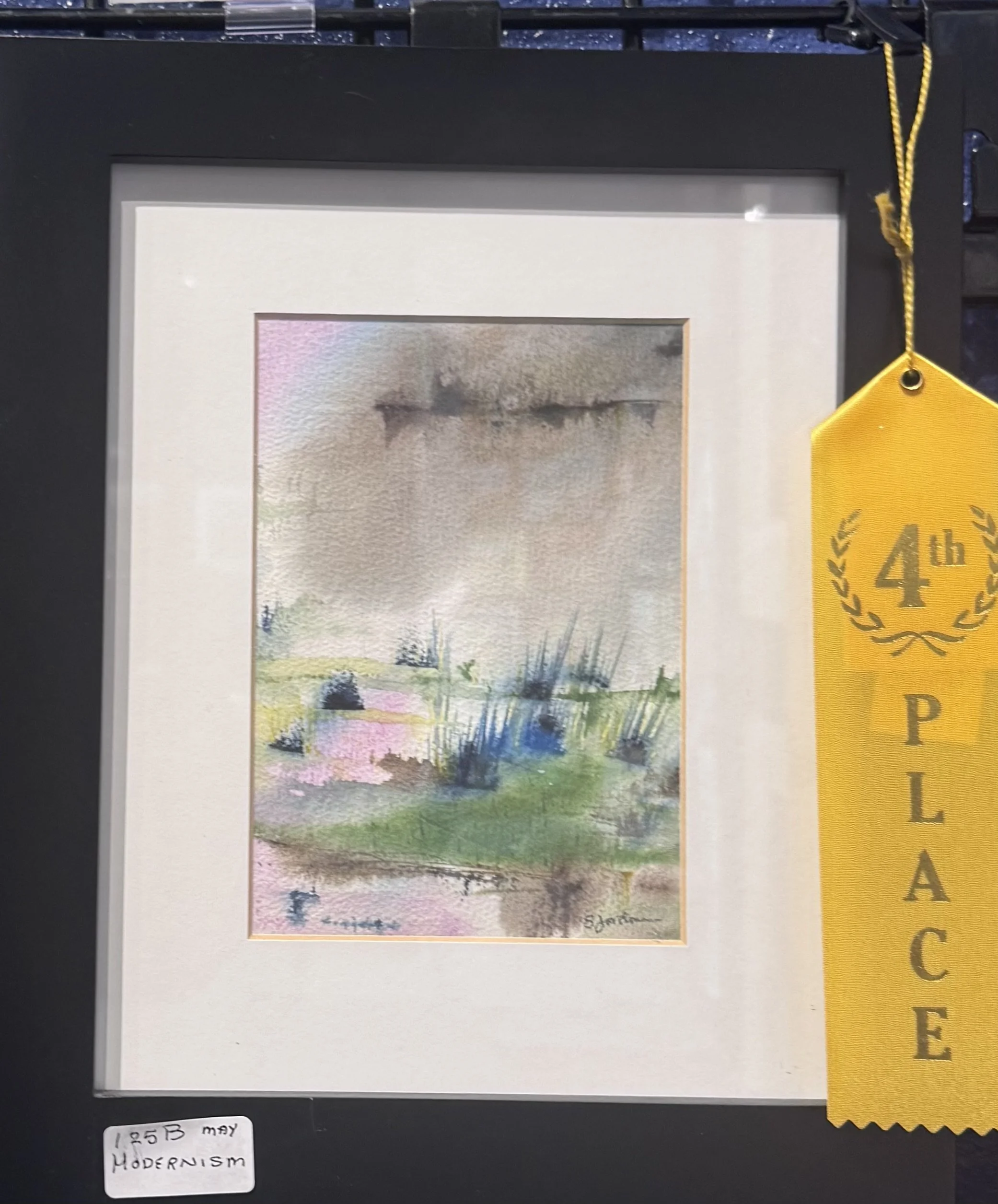 Colorful abstract watercolor landscape painting featuring trees, grass, and a water body, with a signature at the bottom right corner.