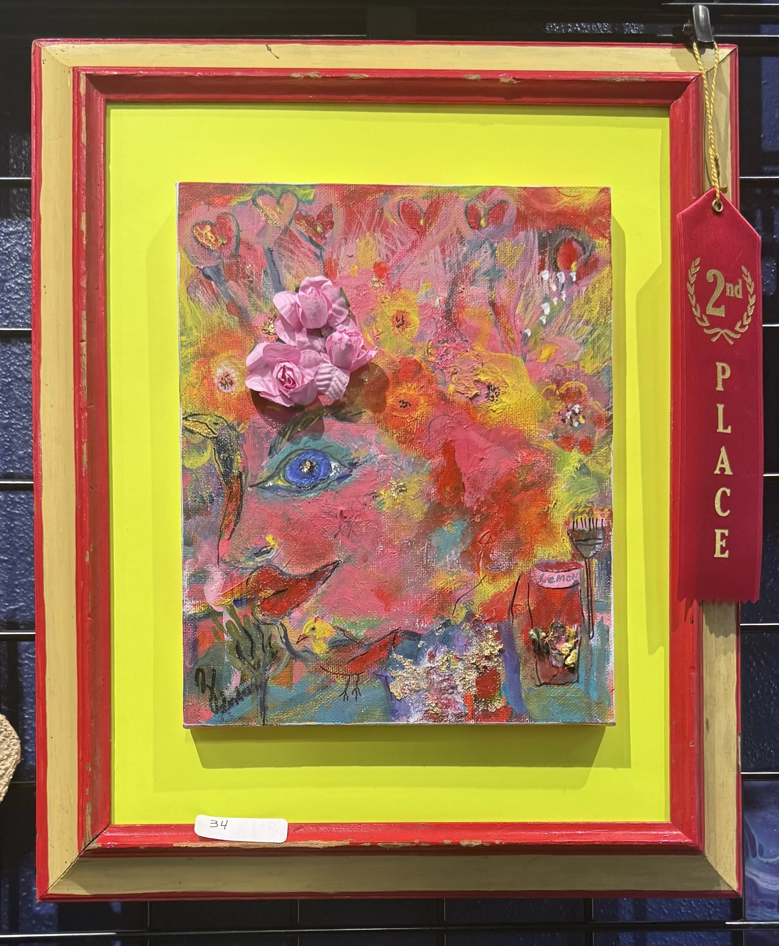 Colorful abstract painting with pink flowers, located within a yellow and red frame with a pink ribbon on the top right corner, displaying a '2nd place' ribbon.