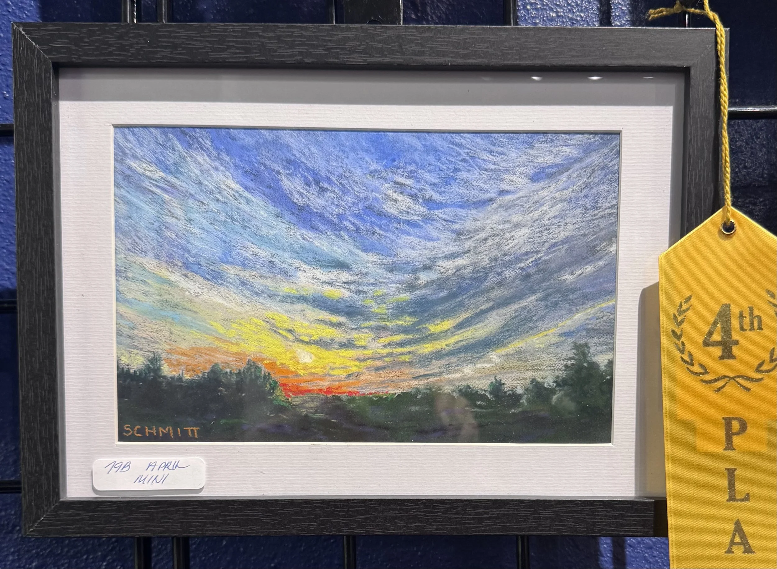 An impressionist painting of a sunset with a swirling sky in shades of blue, white, and yellow, over a landscape with trees and grass, signed by Schmitt.