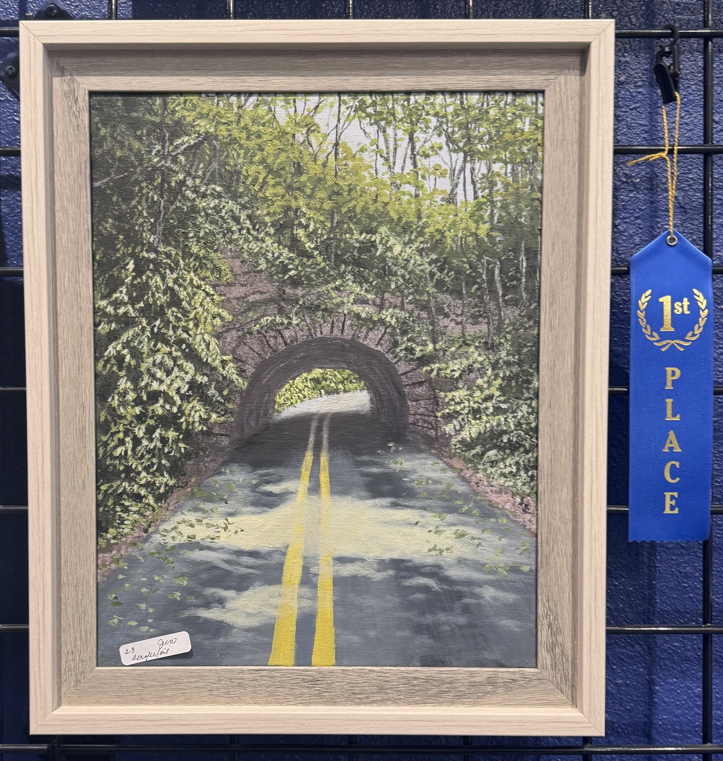 Painting of a forest with trees, a rocky arch bridge, and a yellow line marking a road that runs through the scene.