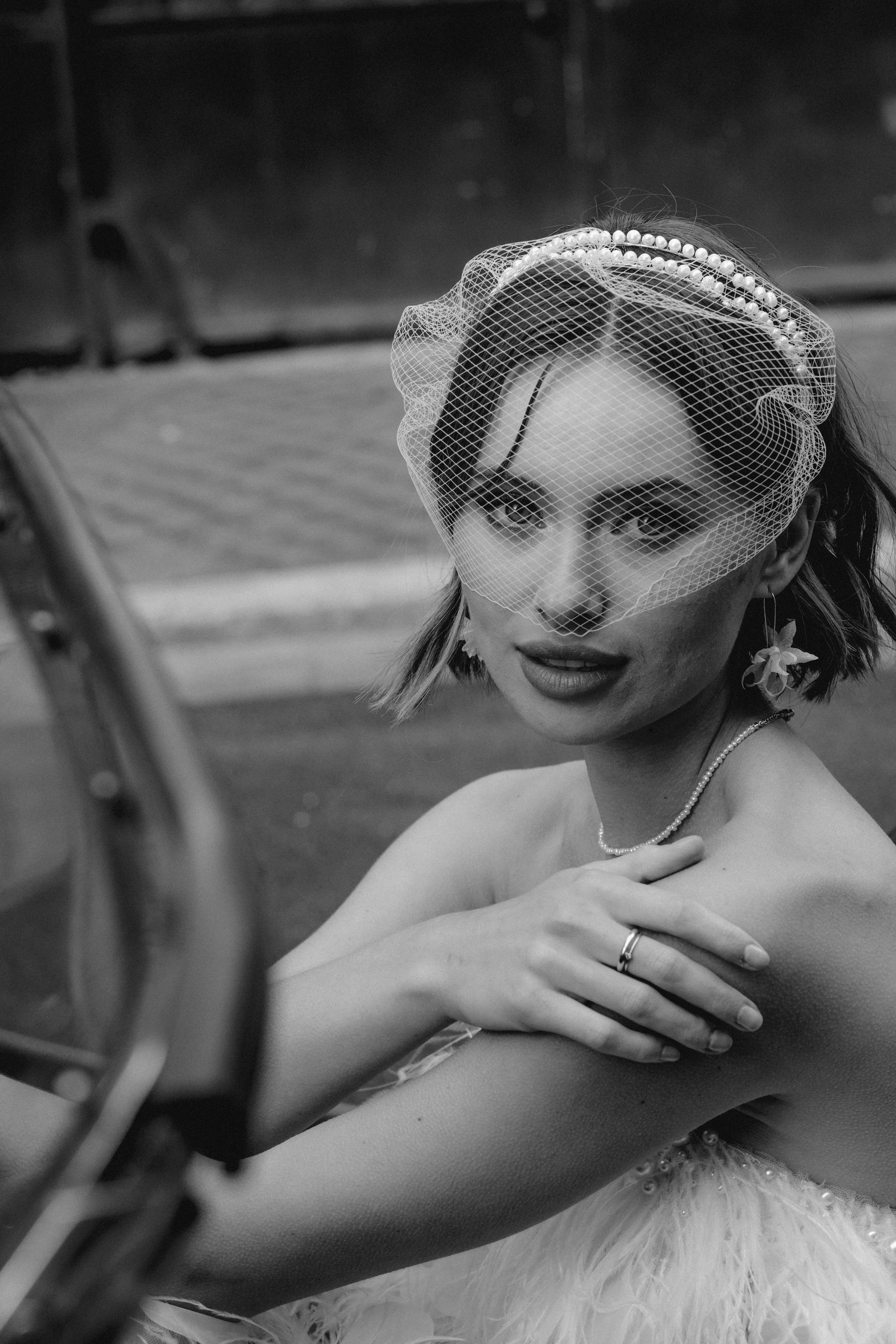 A refined bridal portrait featuring a delicate veil and pearl details, captured in black and white with an editorial, fine-art wedding photography style.