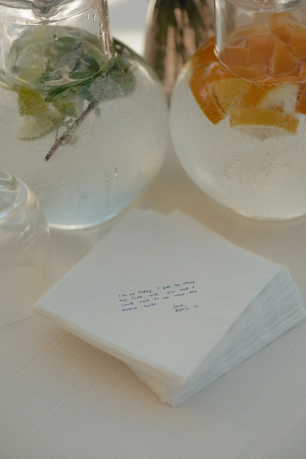 A still life of refreshing drinks infused with herbs and citrus, paired with handwritten vow notes during a summer wedding in Tuscany.