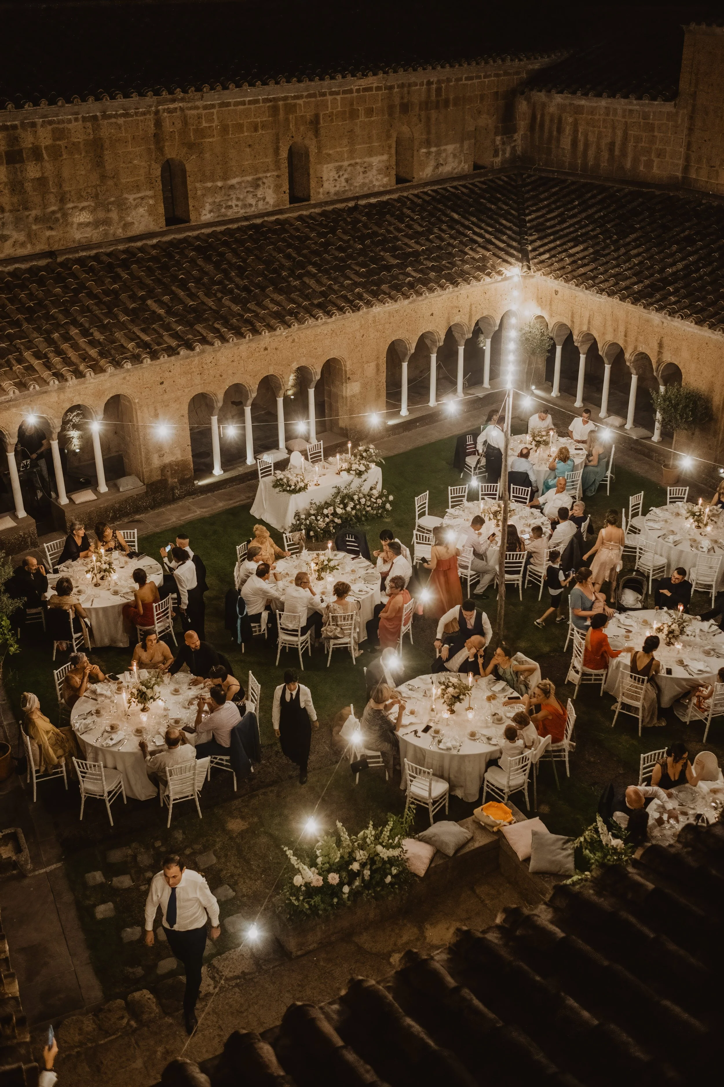 An intimate wedding dinner in Italy, photographed from above to capture atmosphere, guests, and the rhythm of a refined celebration.