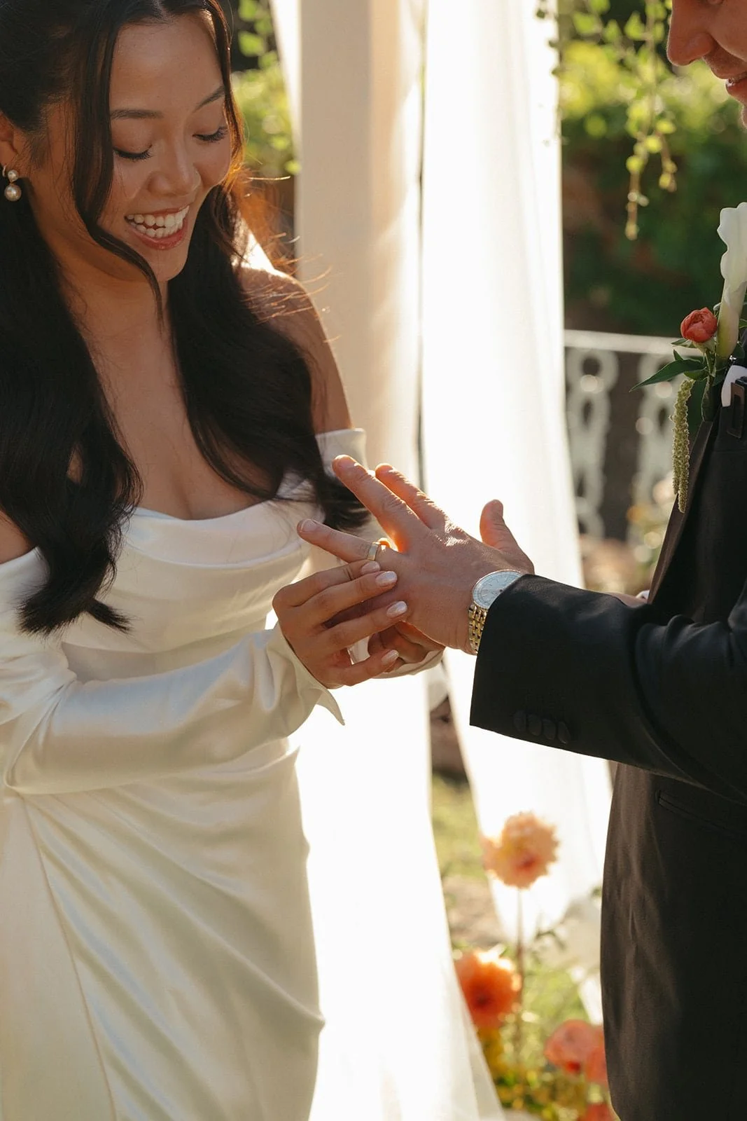 The bride gently places the wedding ring on the groom’s finger, captured during an intimate ceremony beneath the Tuscan sun.