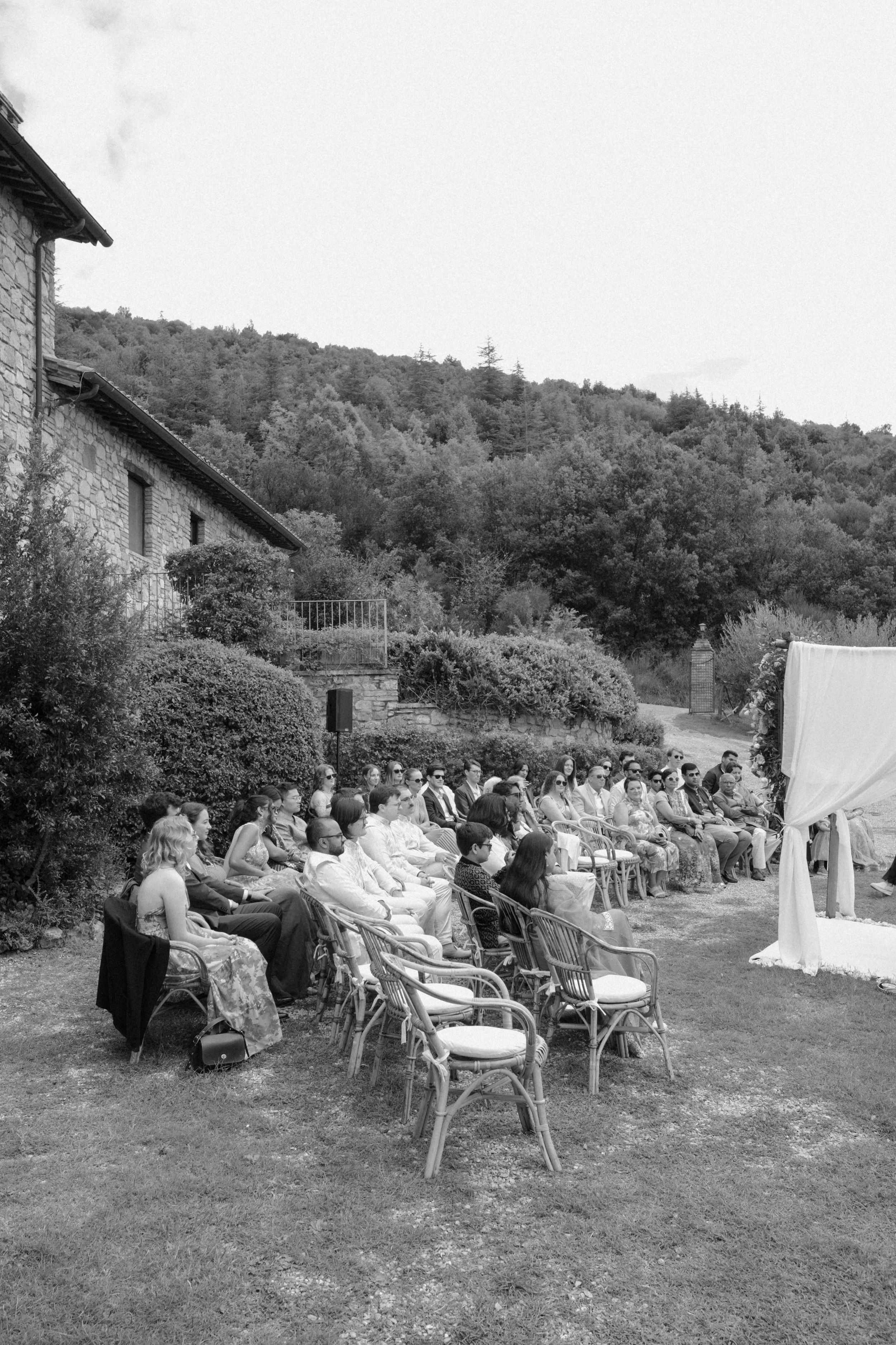 Guests seated during an intimate Indian wedding ceremony in the Tuscan countryside, captured in timeless black and white.