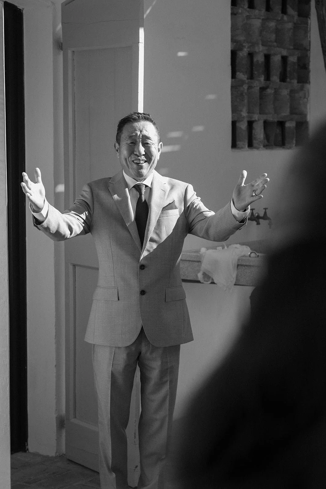 The bride’s father opens his arms in an emotional first look moment inside the villa before the ceremony.
